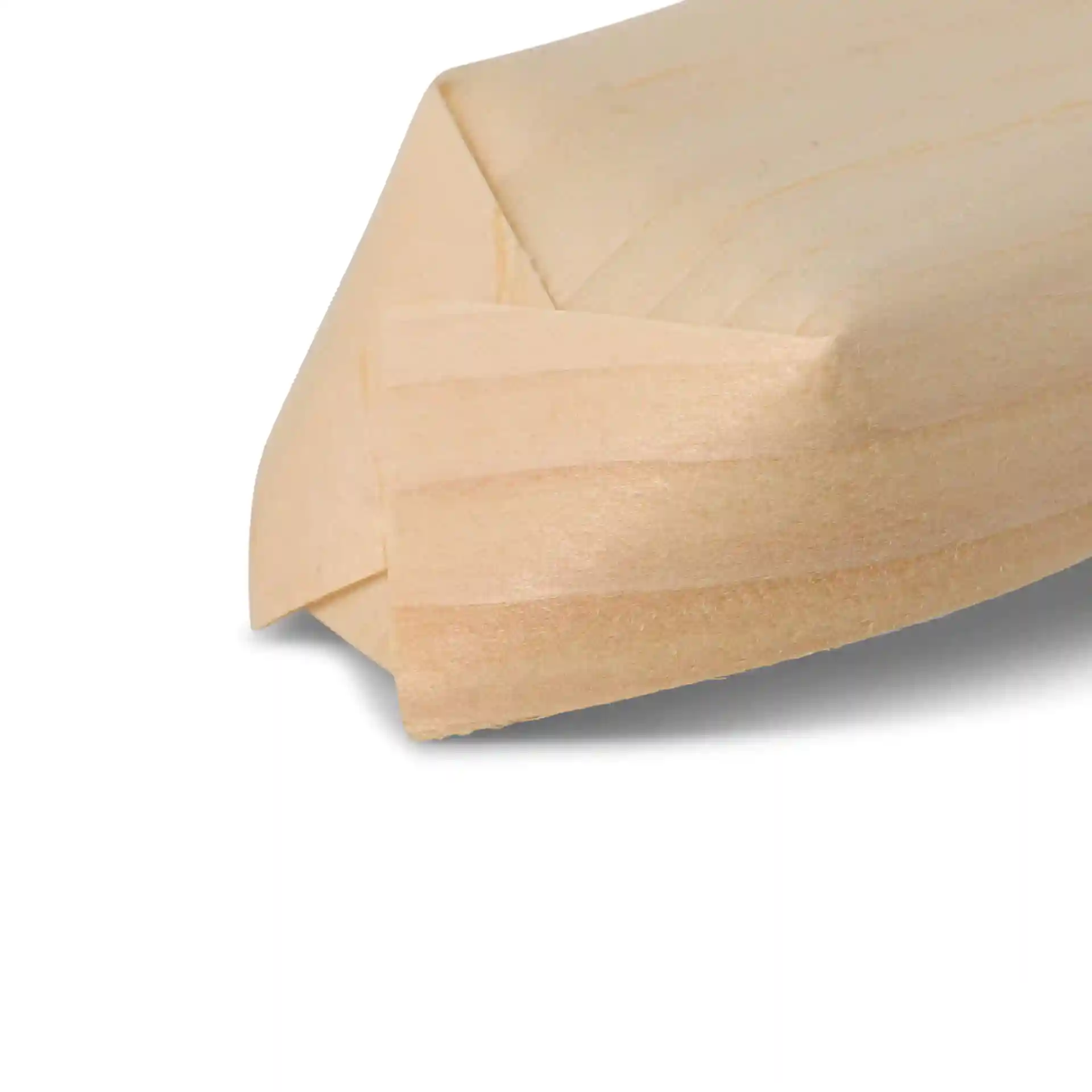 Gros plan d'un objet en bois en forme de bateau avec une surface lisse, brun clair et des bords angulés.