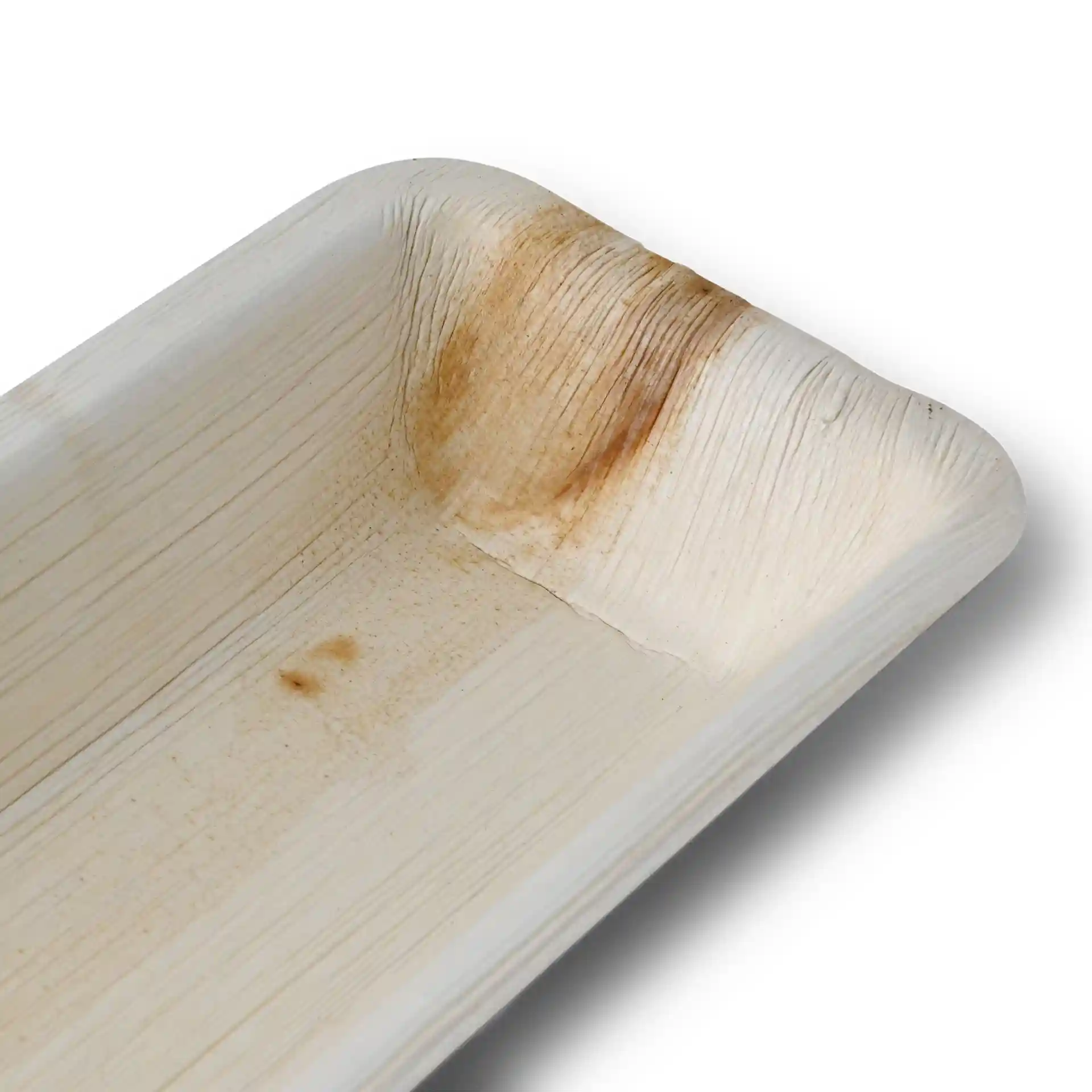 Plateau rectangulaire en feuille de palmier avec une surface à grain texturé et une légère décoloration dans un coin.