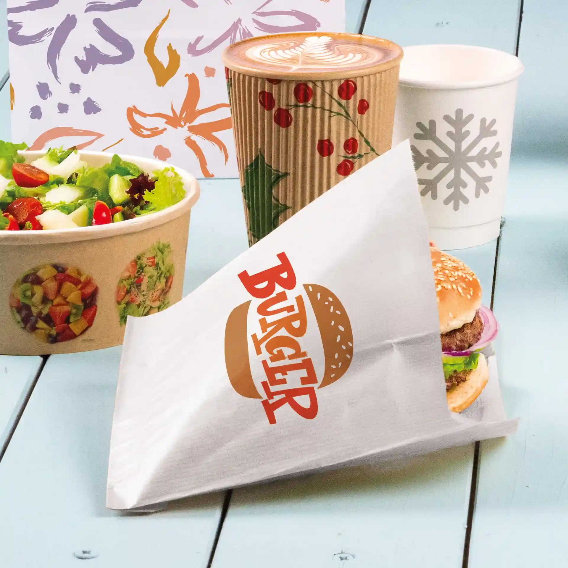 Manchette de burger blanche avec le texte imprimé "BURGER", tenant un burger avec un pain au sésame, de la laitue et des oignons, à côté d'une salade et de boissons.