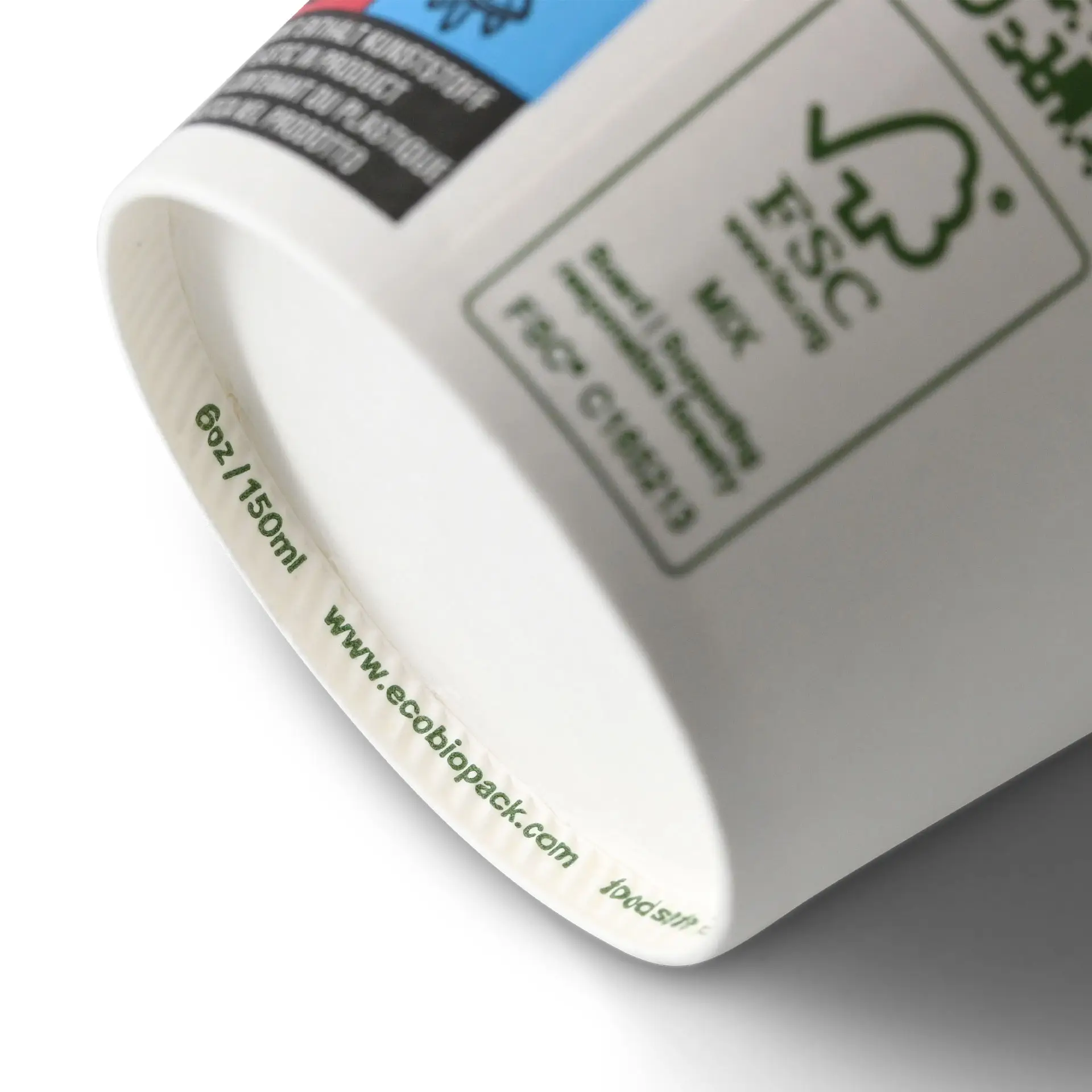 Un gobelet blanc biodégradable montrant sa base avec des marquages de taille ; comporte des étiquettes et des labels de certification.