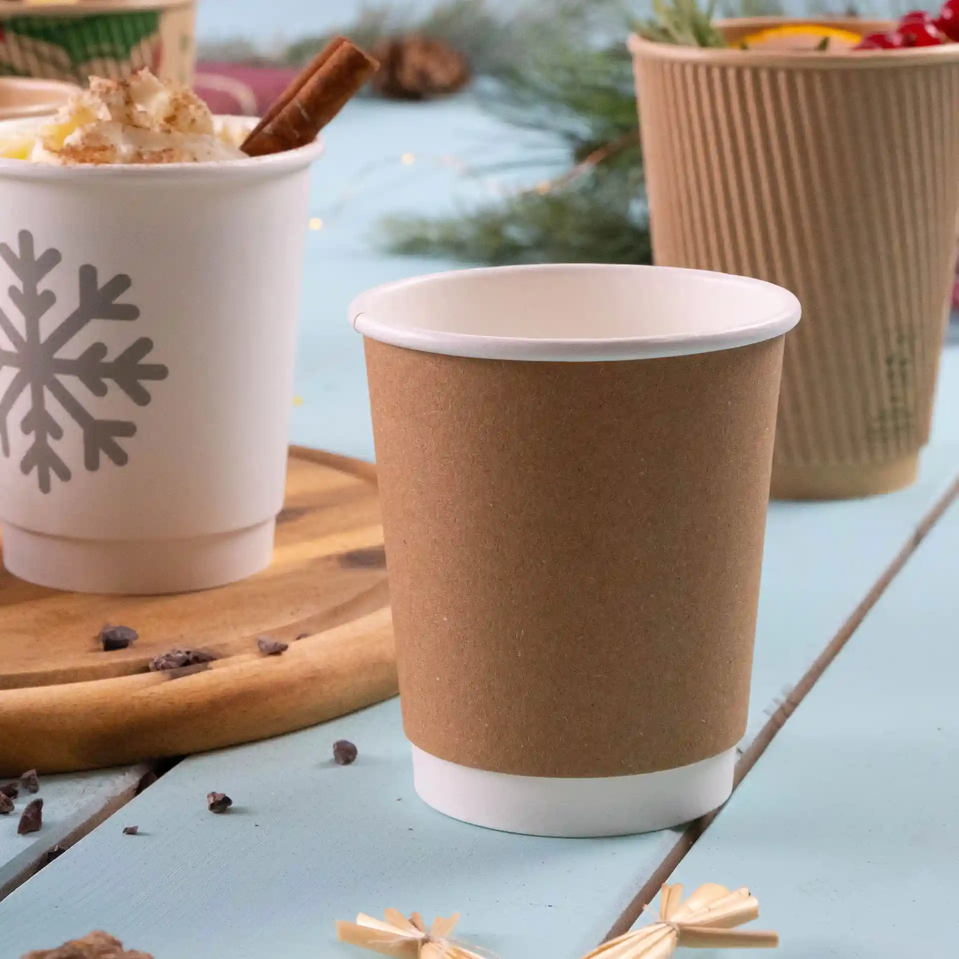 Tasse à café double paroi marron avec intérieur blanc, capacité de 200 ml, posée sur une surface en bois avec d'autres tasses en arrière-plan.