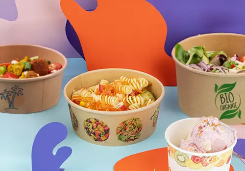 Bol biodégradable marron pour salade avec des salades assorties ; un bol est ouvert avec un couvercle à proximité.