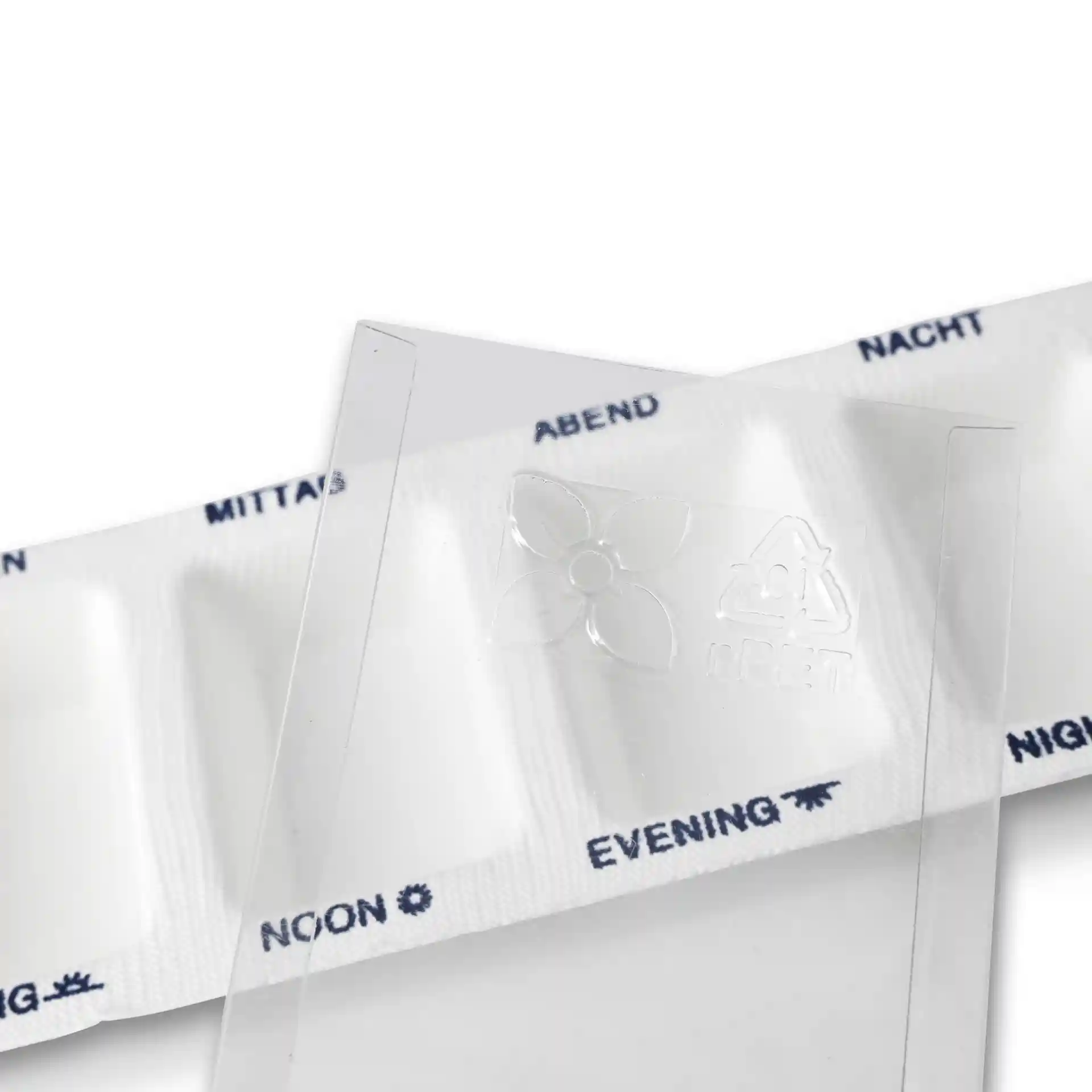 Distributeur de médicaments transparent avec quatre compartiments et un couvercle coulissant, comportant des repères pour différents moments de la journée.