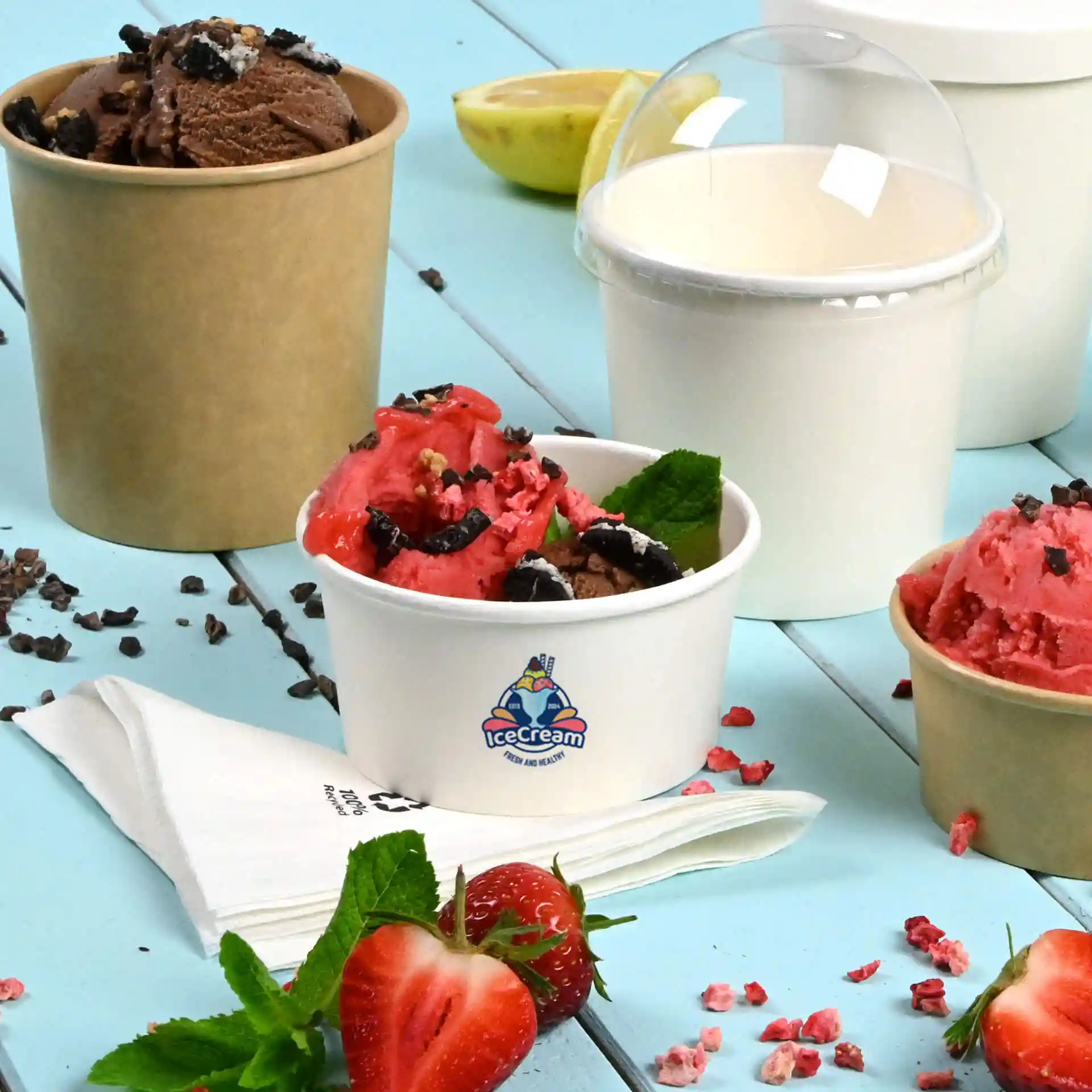 Image de plusieurs coupes de glace, y compris une coupe en carton blanc avec de la glace rose et brune, une coupe brune avec de la glace au chocolat et un couvercle transparent.