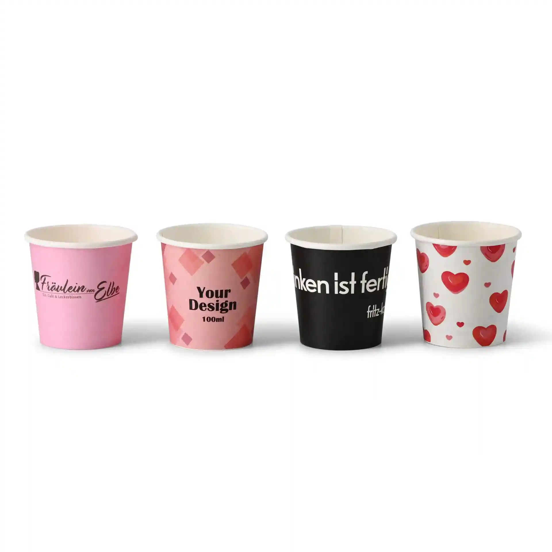 Quatre gobelets en papier avec divers designs : rose avec logo, rose à motif géométrique, noir avec texte et blanc avec des cœurs.