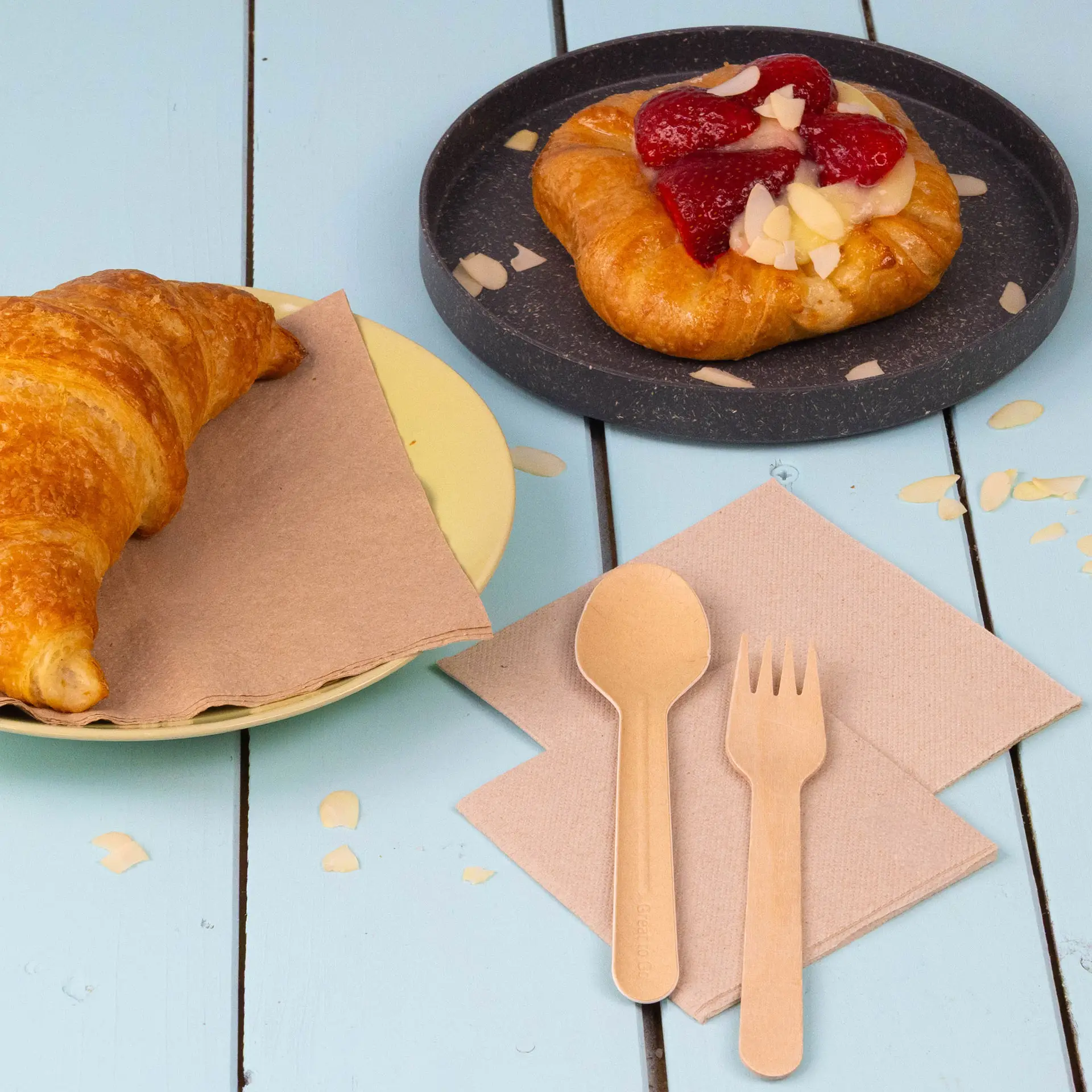 Serviette carrée non blanchie sur une surface en bois avec un bretzel à côté.