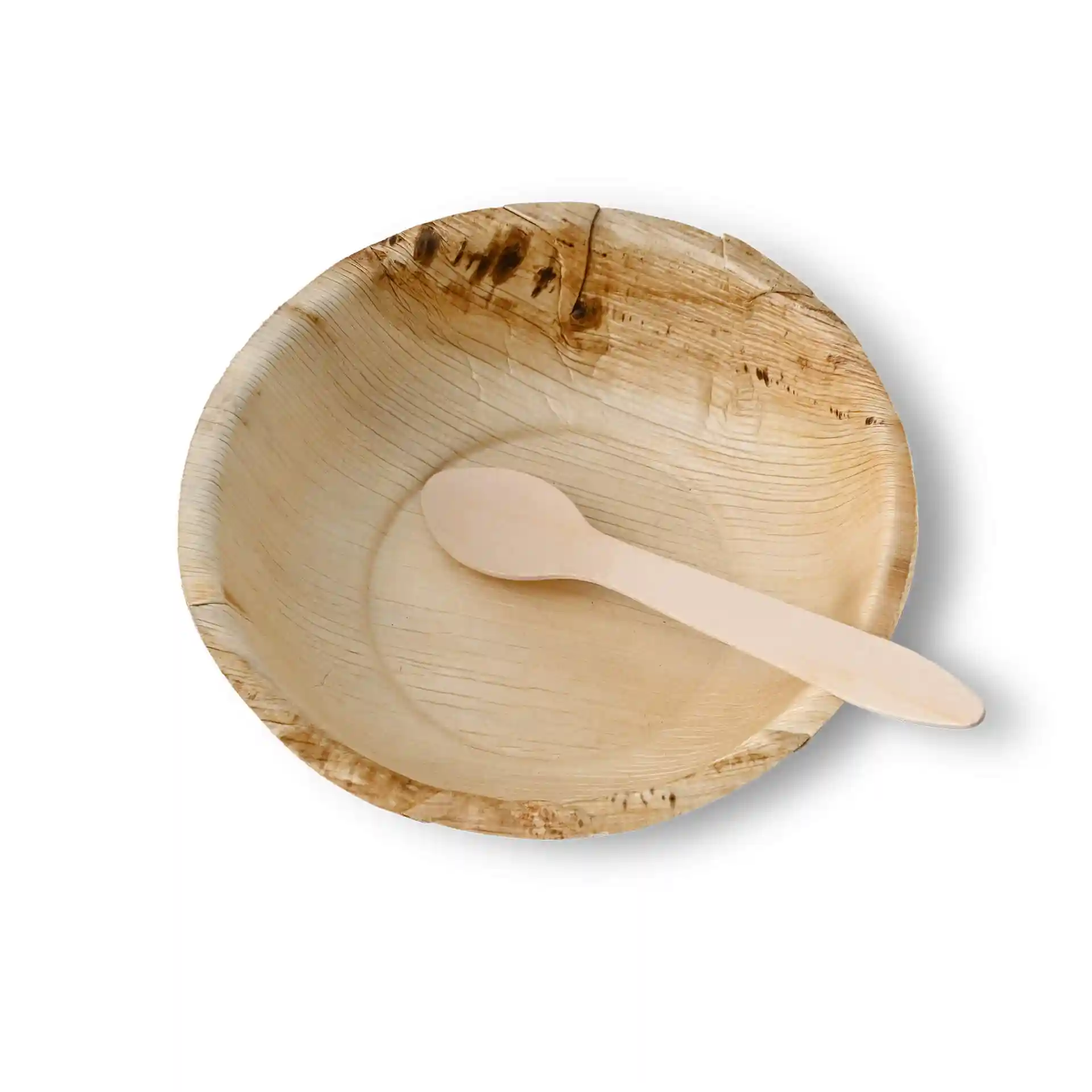 Bol rond en feuille de palmier avec une cuillère en bois à l'intérieur, montrant une texture naturelle.