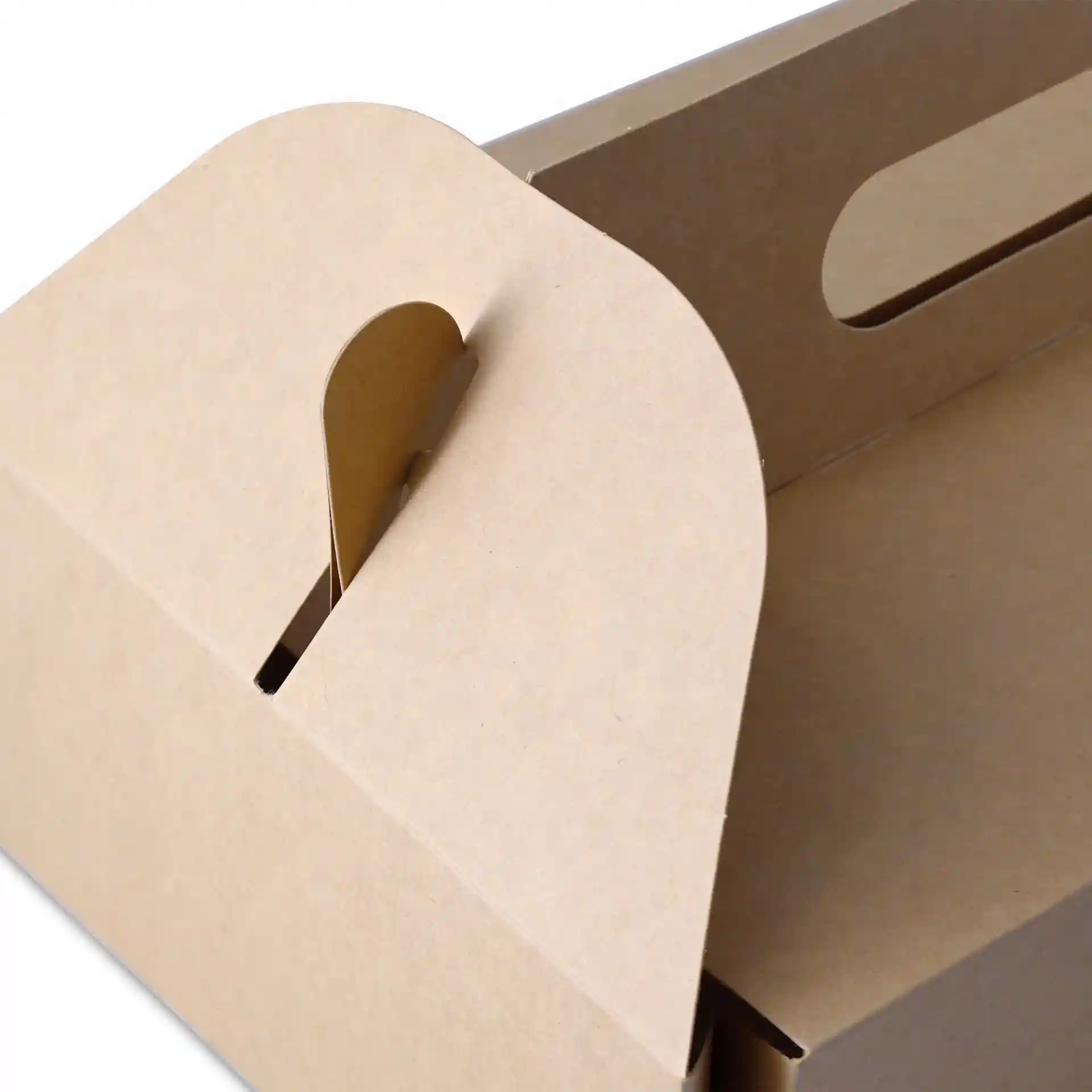Boîte à pâtisserie en carton brun avec une poignée, montrant le bord supérieur et la fente de fermeture.