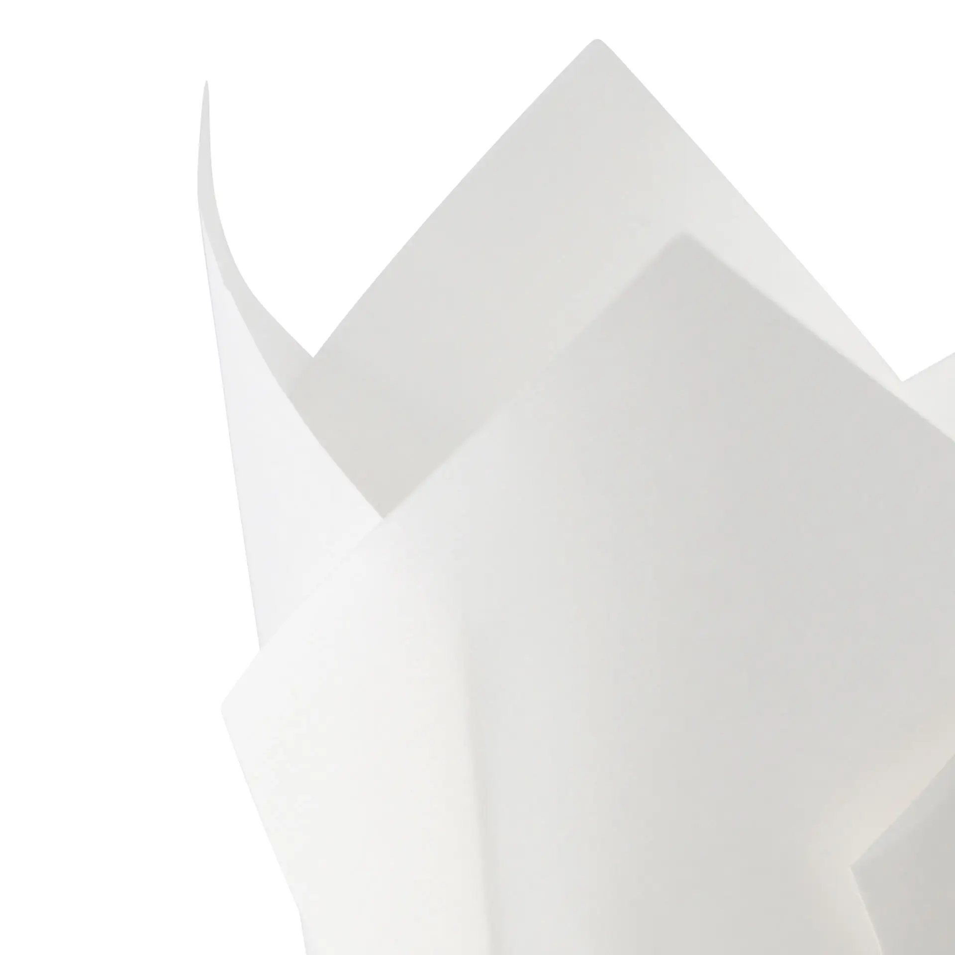 Un moule à muffin blanc en papier imperméable avec des bords pointus; plusieurs moules similaires sont partiellement visibles derrière lui.