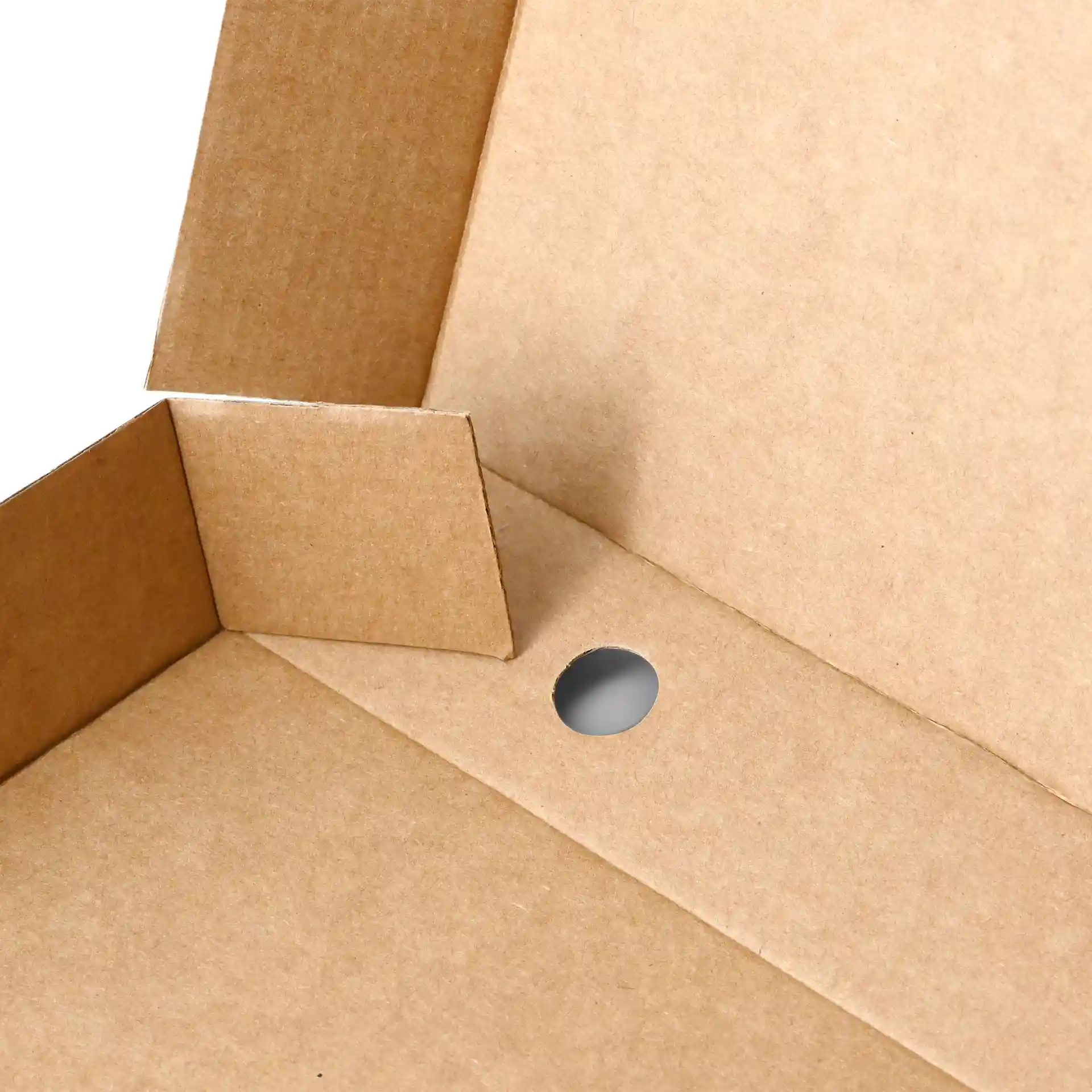 Gros plan d'une boîte à pizza en carton brun avec un trou circulaire et des rabats repliés.