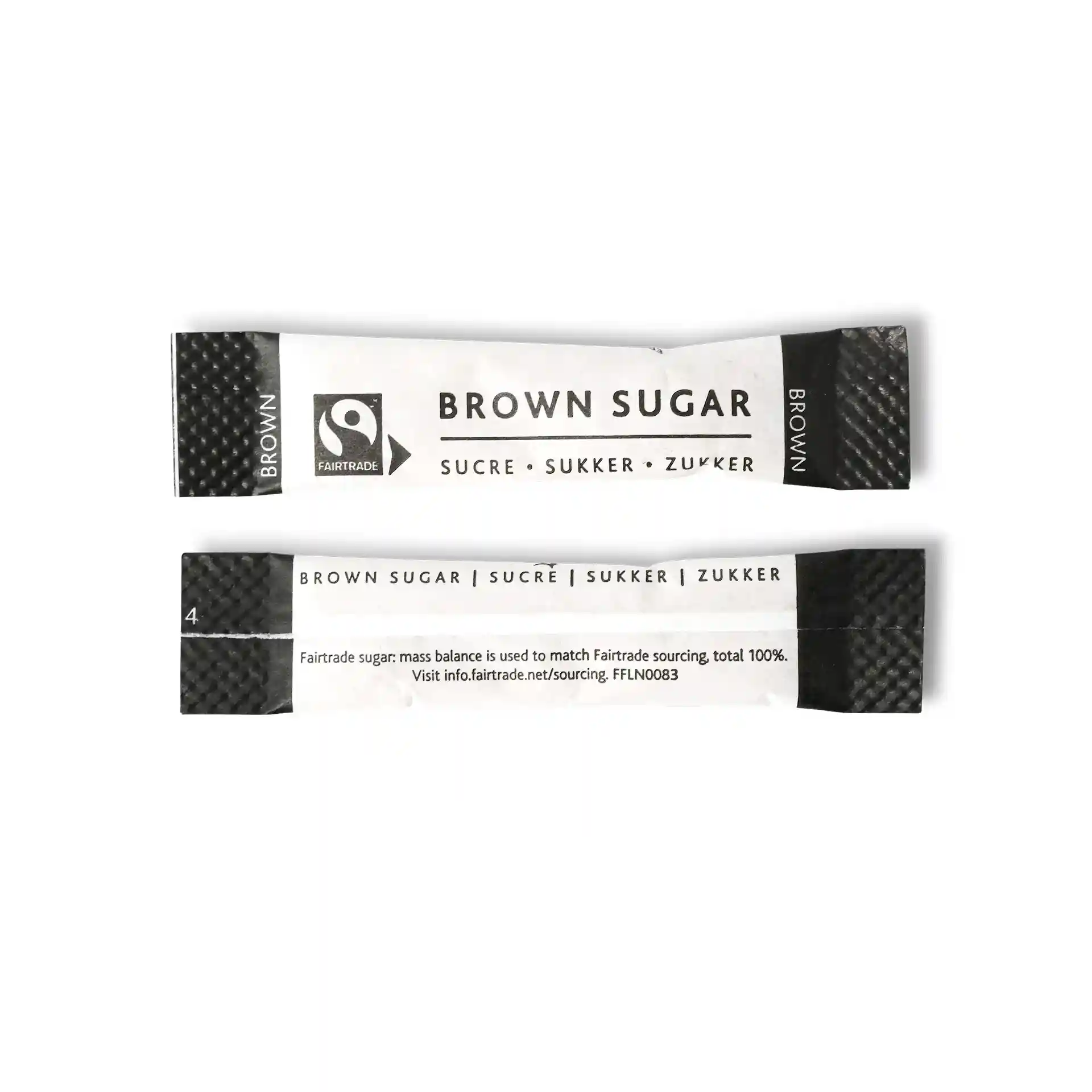 Bâton de sucre brun avec logo Fairtrade, mesurant 74 mm sur 16 mm, avec du texte en plusieurs langues.