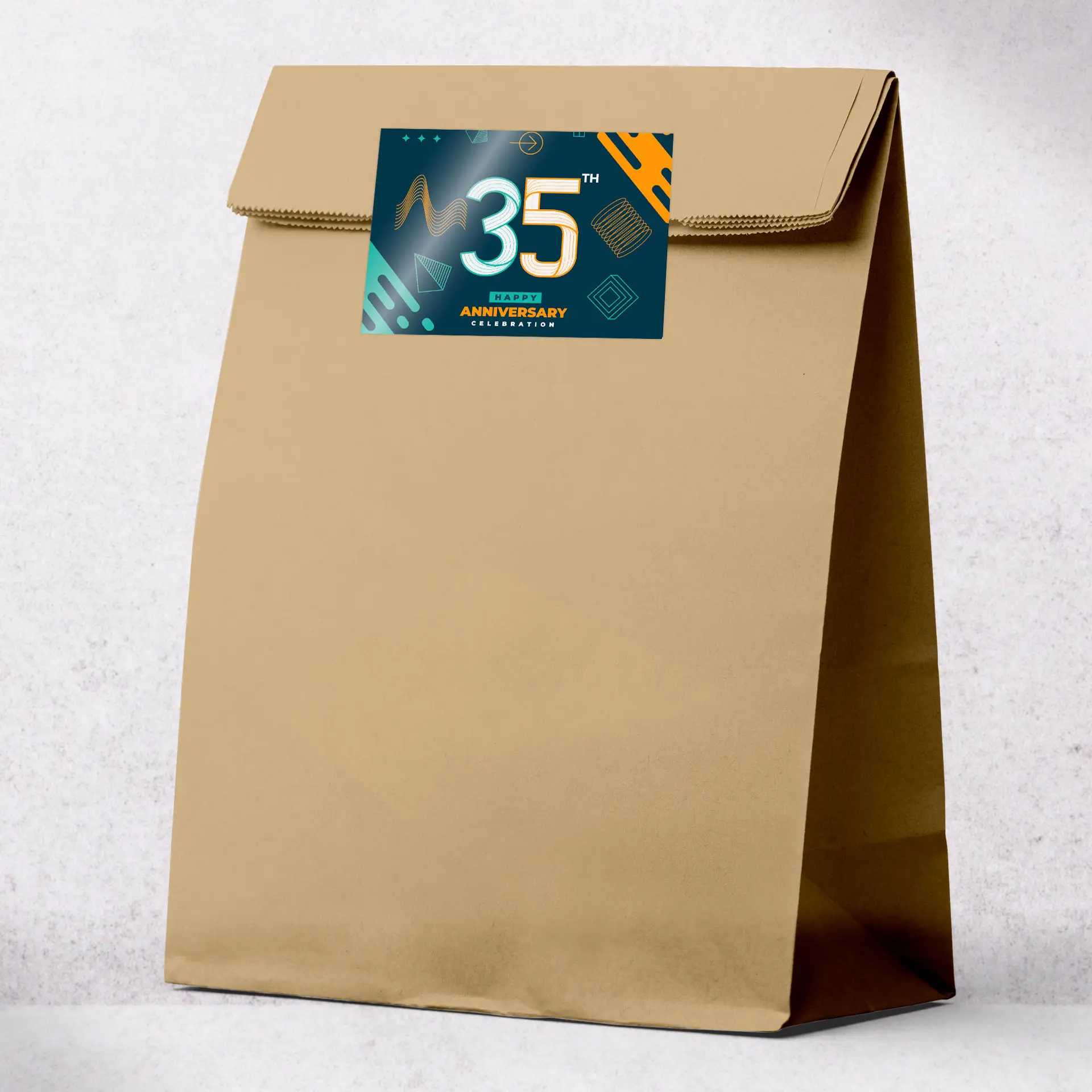 Sac en papier kraft brun avec une étiquette imprimée représentant le design "Célébration du 35e anniversaire".