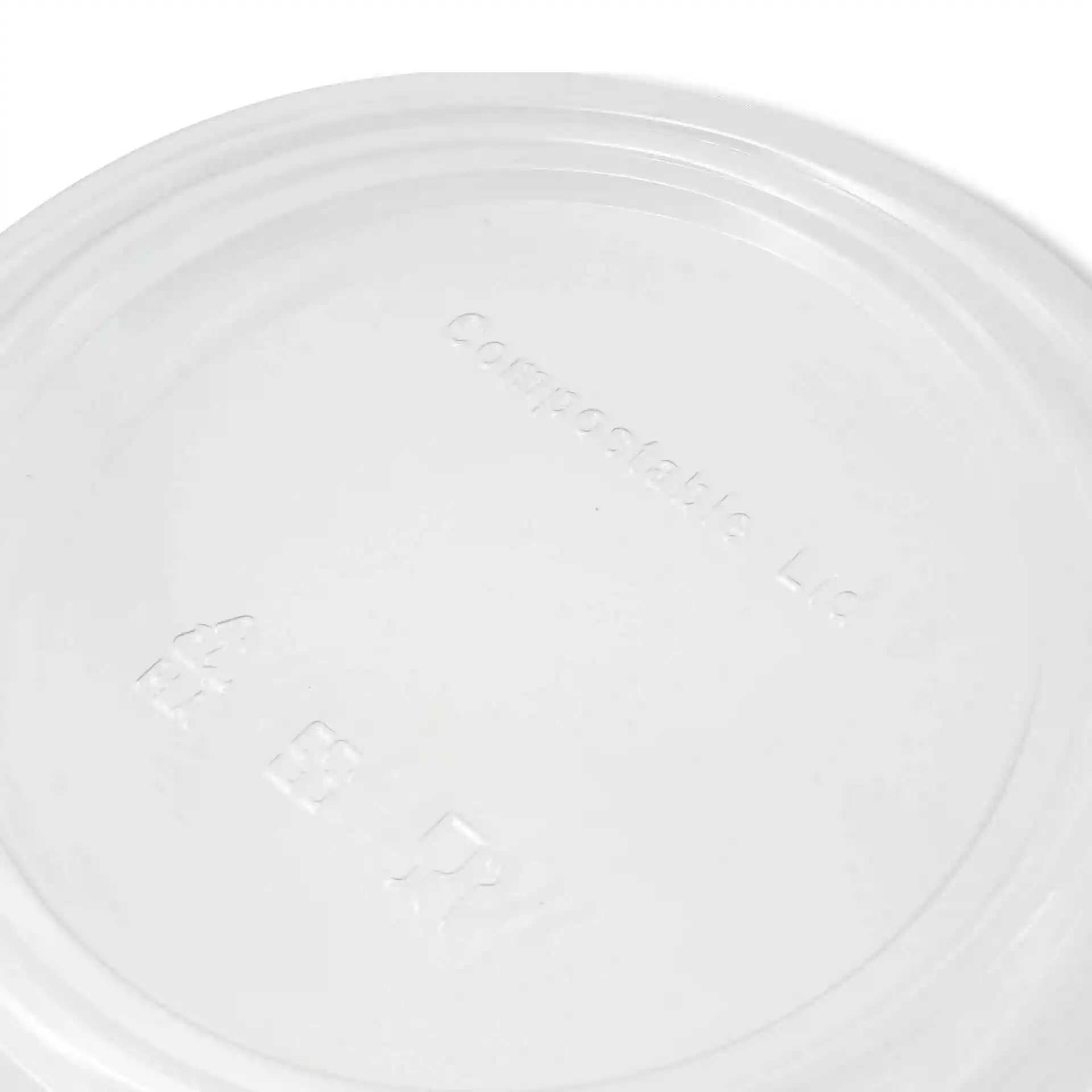 Couvercle rond transparent en PLA, présentant des marquages en relief sur la surface.