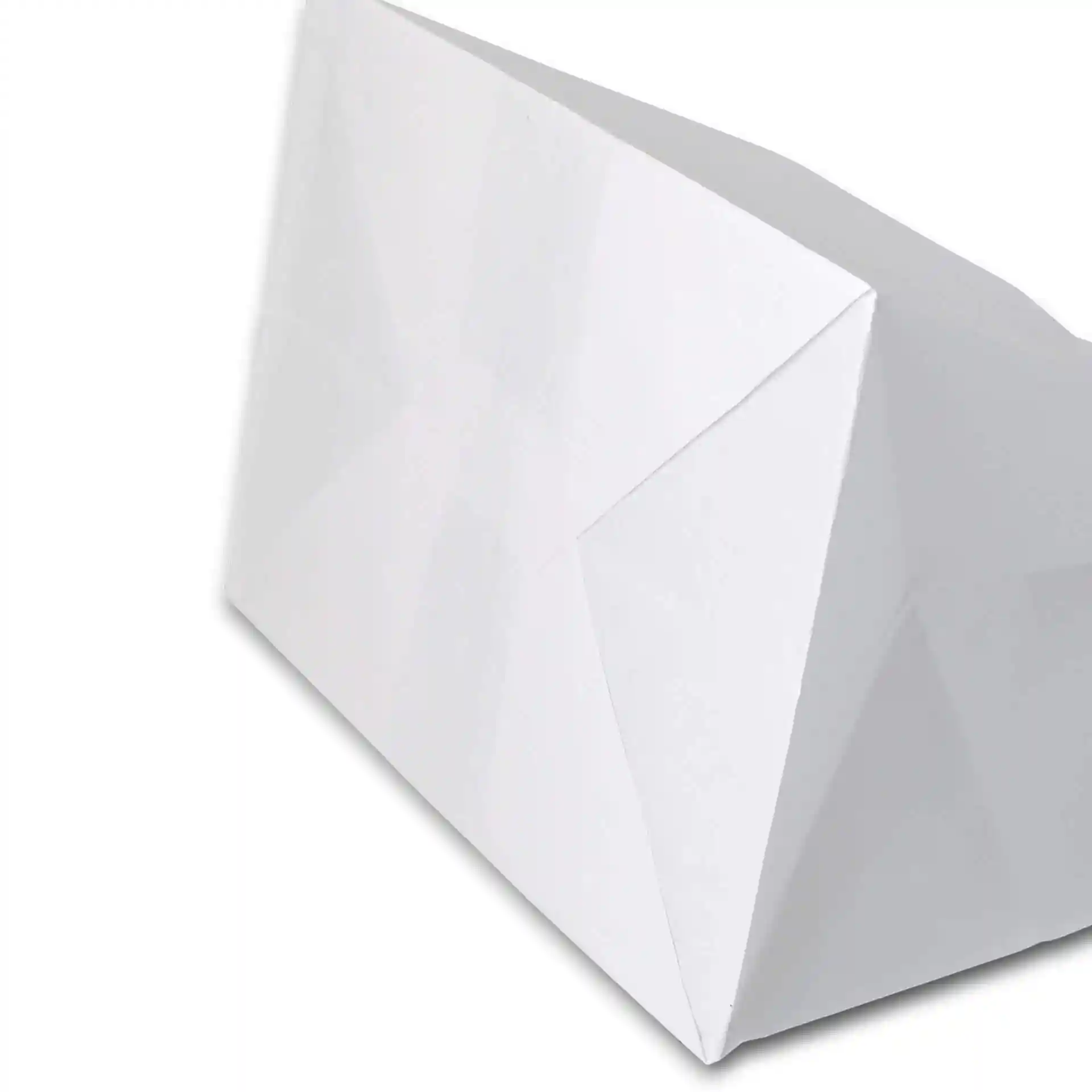 Sac en papier kraft blanc avec une large base, montrant un coin plié et une vue en angle.
