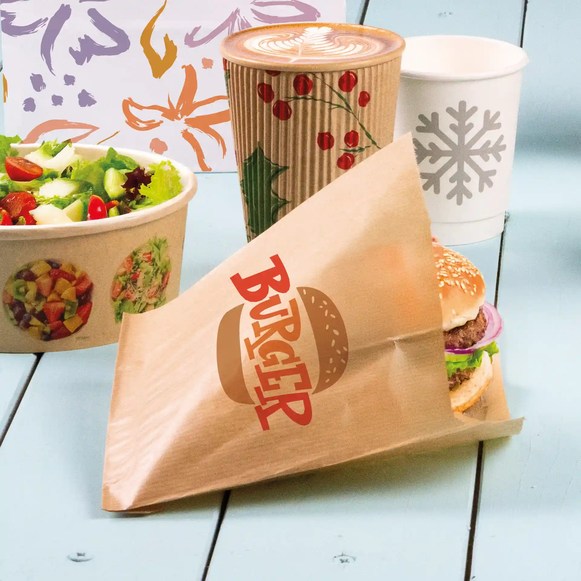 Manchette de burger imprimée marron avec un burger visible, un bol de salade et une tasse de café en arrière-plan.