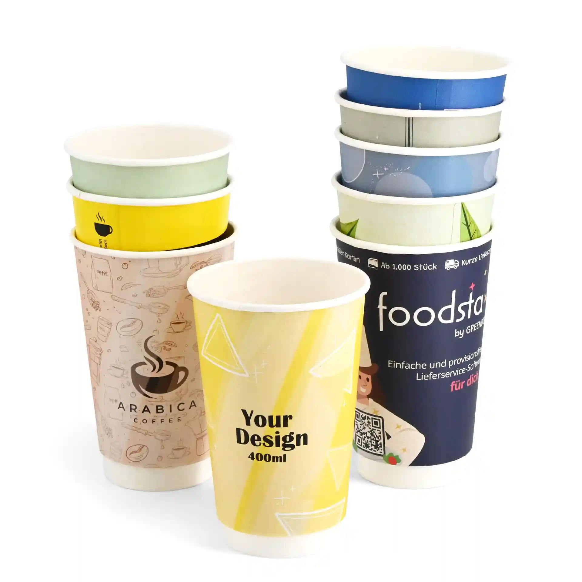 Empilement de gobelets en papier personnalisés avec divers designs, montrant un gobelet jaune avec "Votre Design" et un gobelet sur le thème du café.