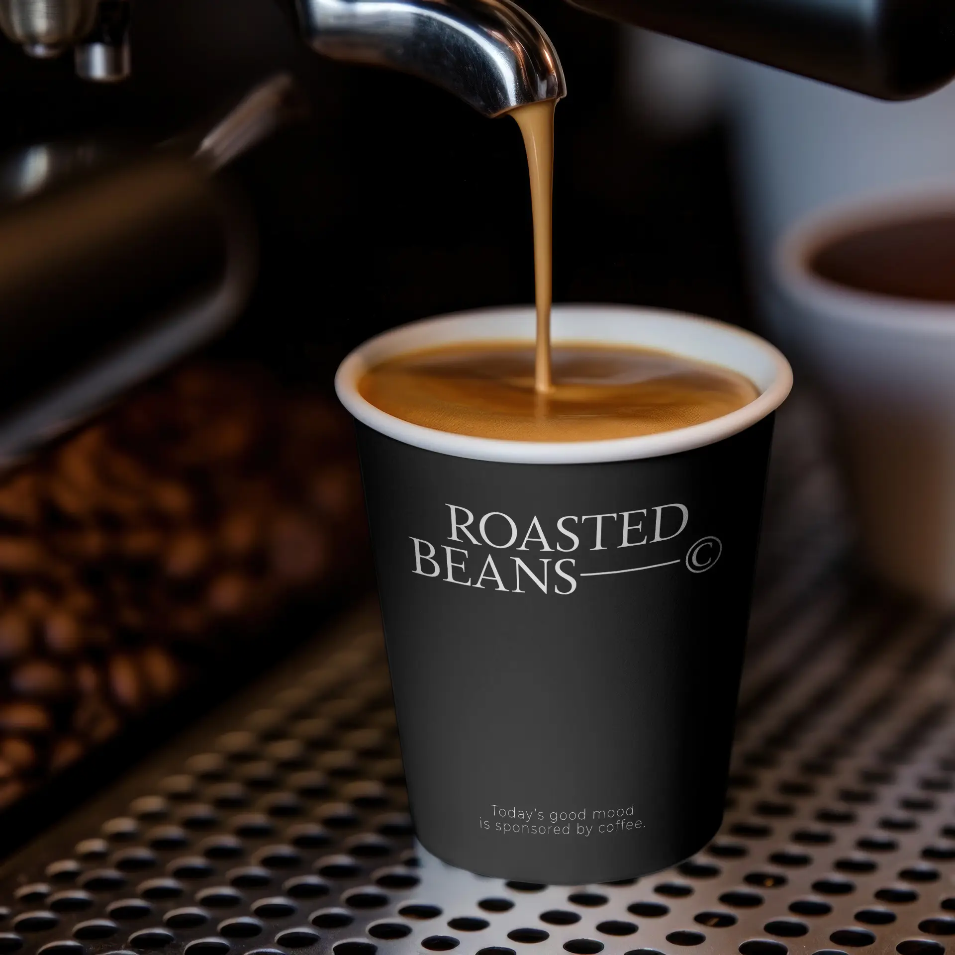 Gobelet noir avec logo, rempli de café, posé sur une surface métallique avec des grains de café en arrière-plan.