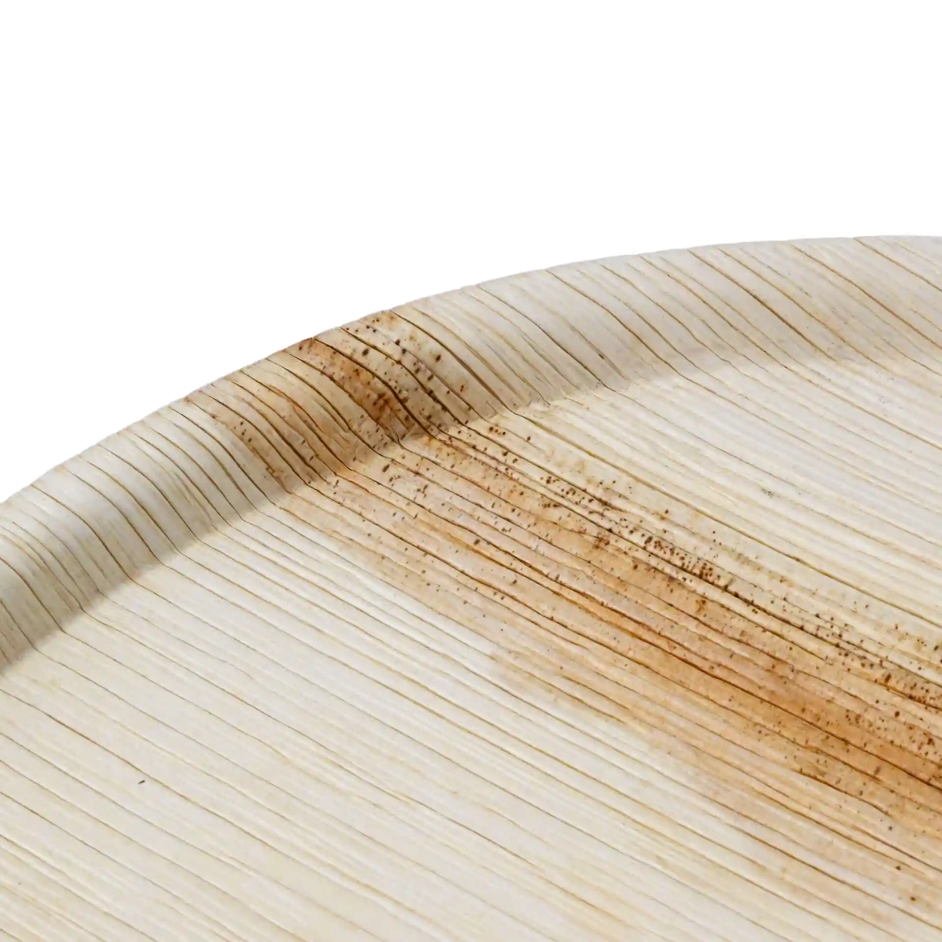Assiette à pizza ronde en feuille de palmier avec une surface texturée et une légère teinte brunâtre sur le bord.