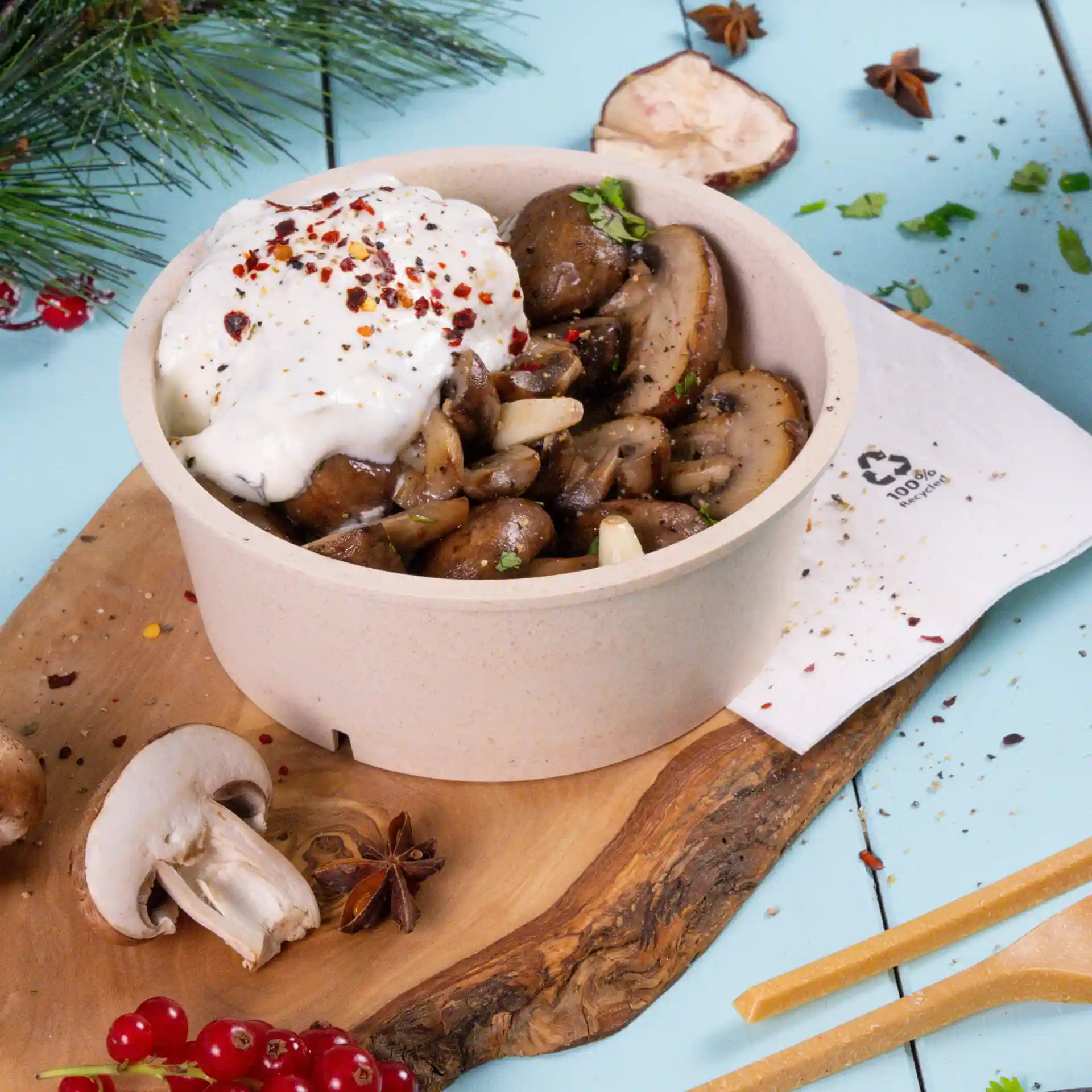 Bol rond crème blanc réutilisable rempli de champignons sautés, surmonté d'une cuillerée de crème et d'épices.