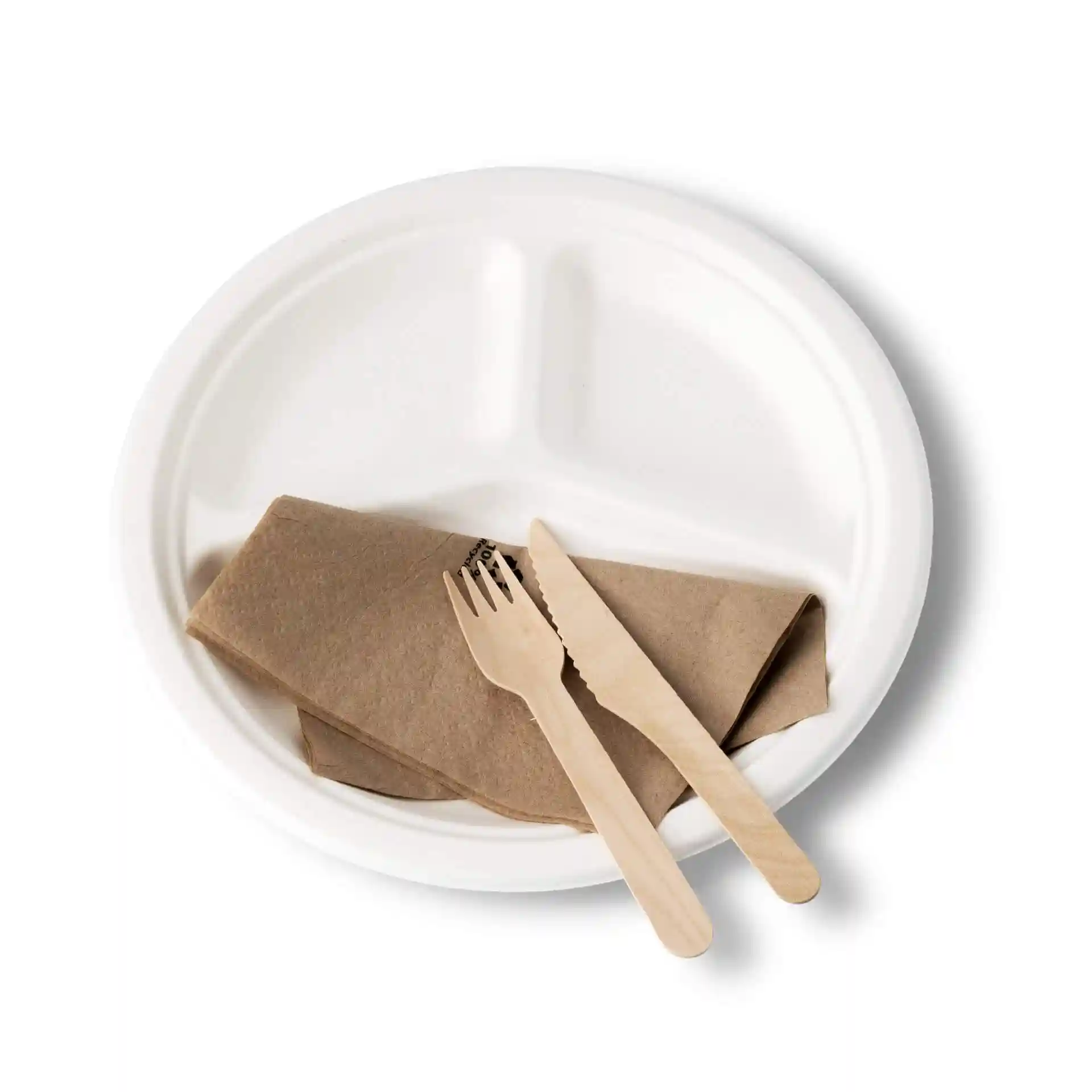 Assiette ronde en canne à sucre blanche avec trois compartiments, une serviette brune et un couteau et une fourchette en bois.