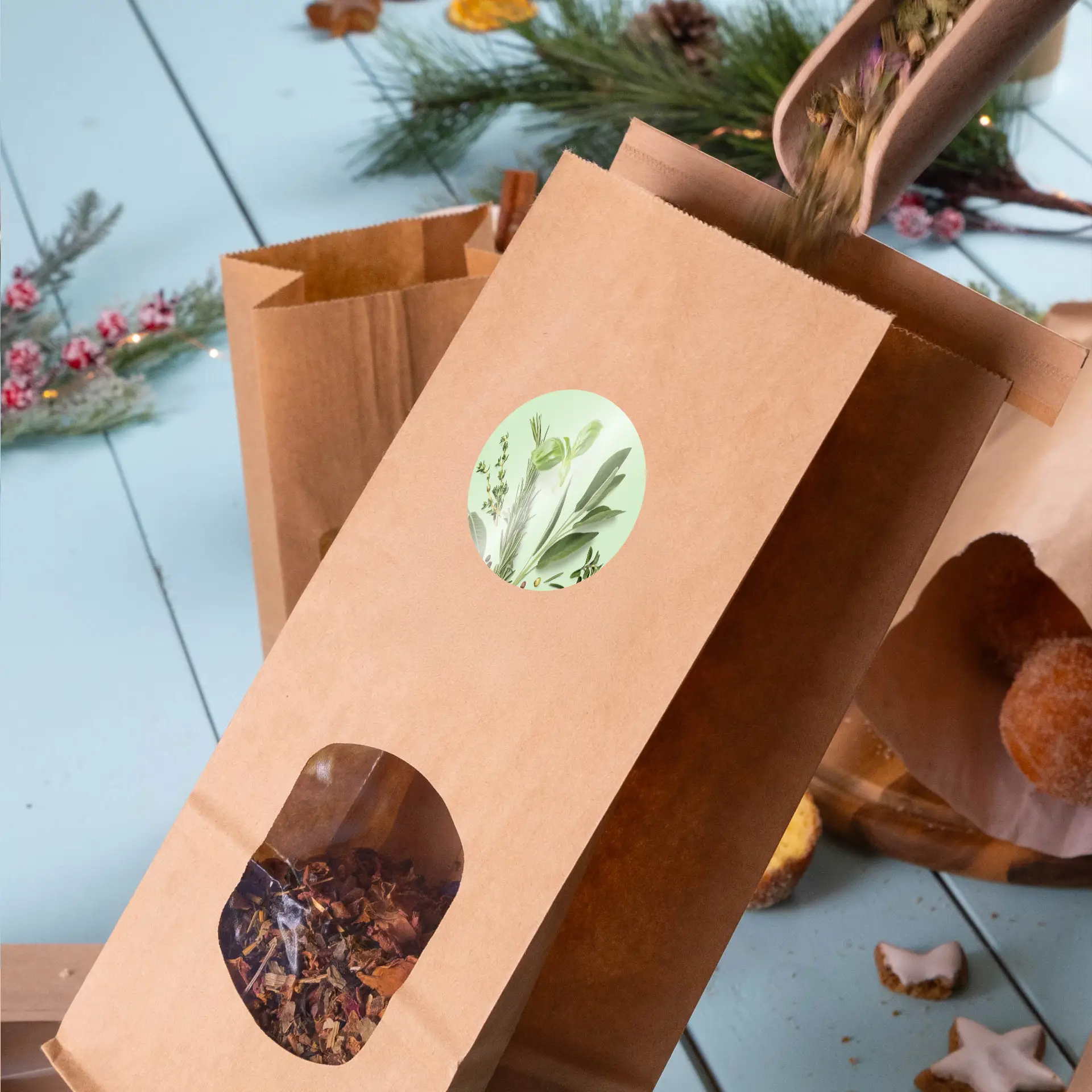 Un sac en papier kraft marron avec une étiquette verte ronde et une fenêtre transparente, rempli d'ingrédients de thé aux herbes en vrac.
