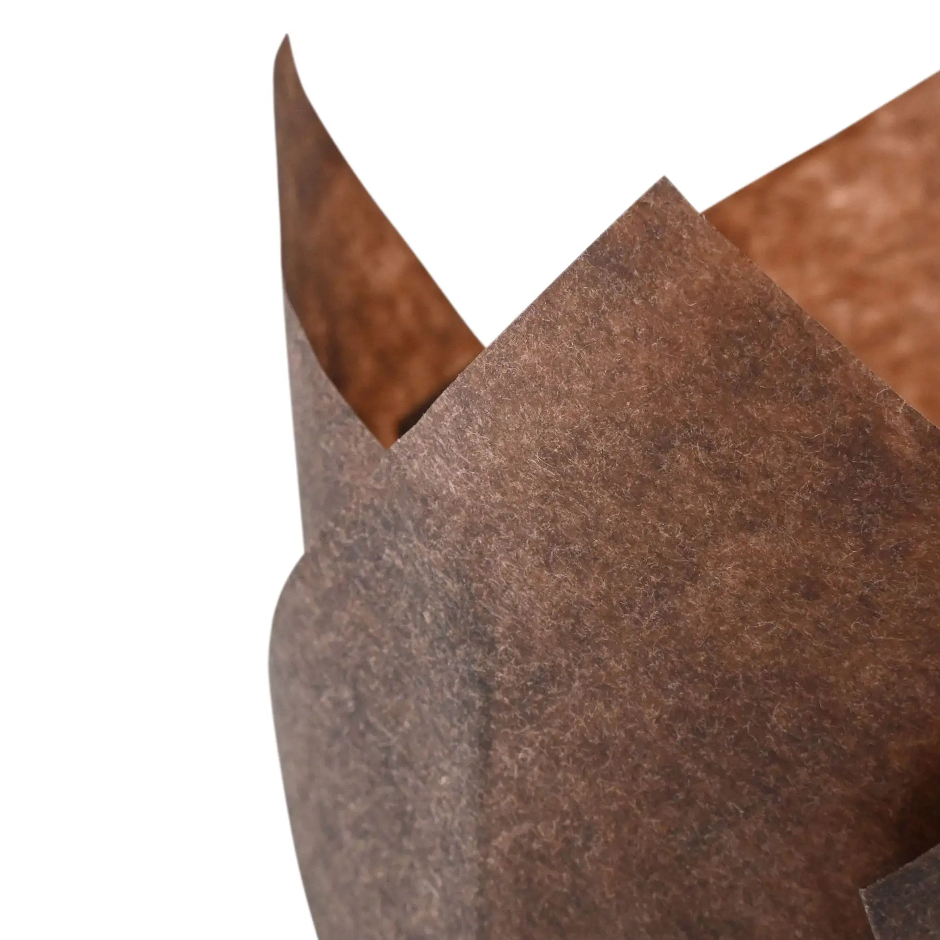 Un moule à muffin en papier brun anti-graisse, avec un bord ondulé, adapté pour la cuisson de cupcakes.