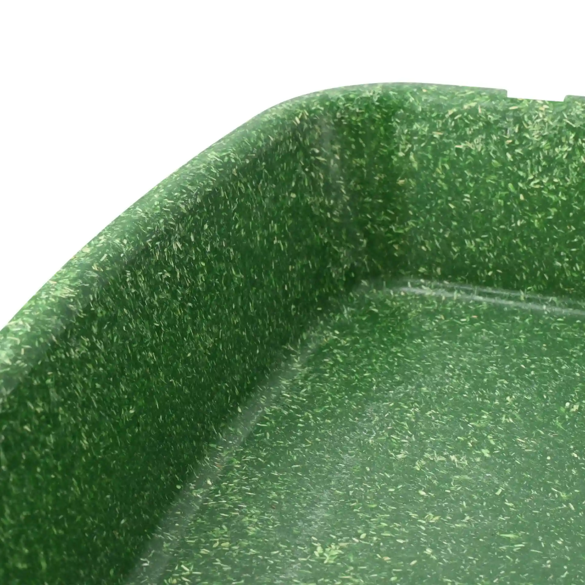 Gros plan d'un contenant de repas réutilisable vert avec deux compartiments et une surface texturée.