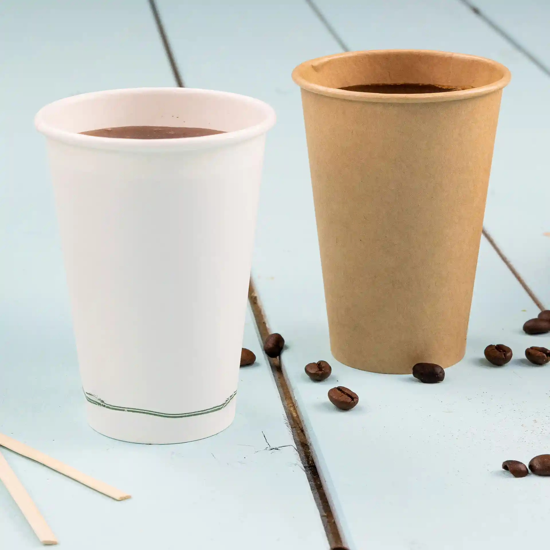 Image de deux gobelets jetables : un gobelet blanc à paroi simple avec une ligne verte à la base et un gobelet brun en PLA, tous deux remplis de liquide.