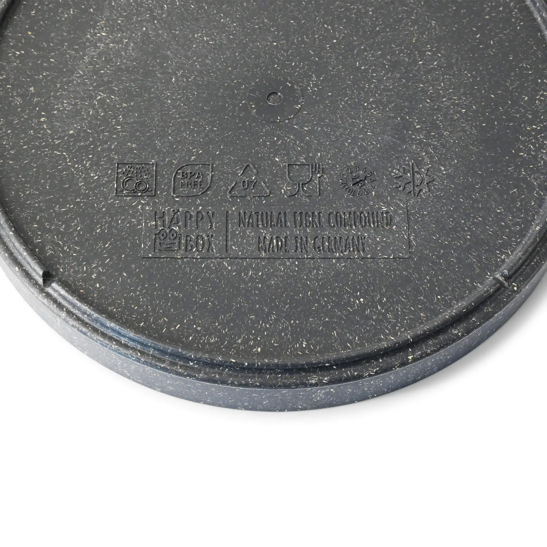 Assiette ronde grise en matériau bio, montrant une surface texturée et divers symboles au fond.