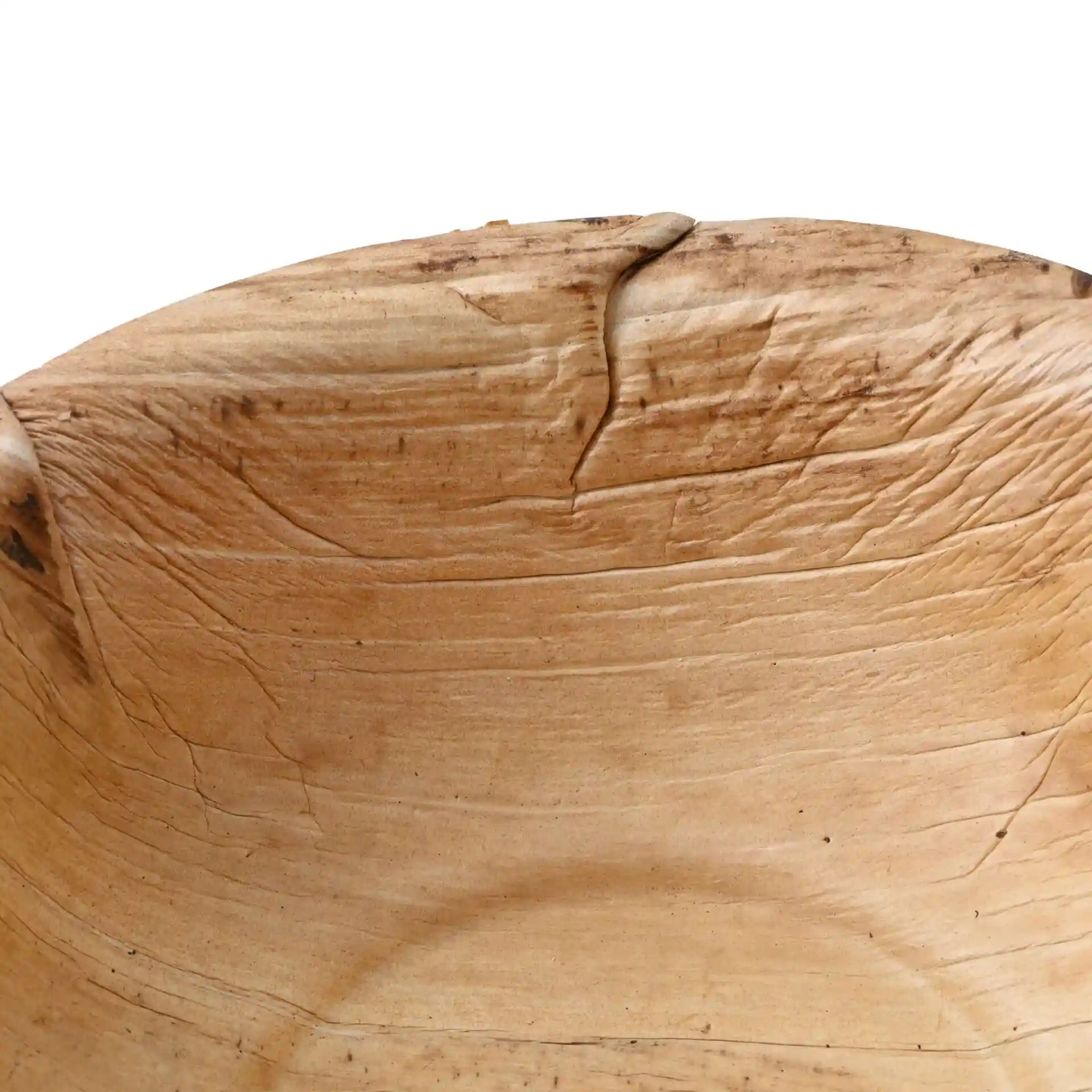 Gros plan d'un bol rond en feuille de palmier avec une texture granuleuse, montrant l'intérieur et les marques naturelles.