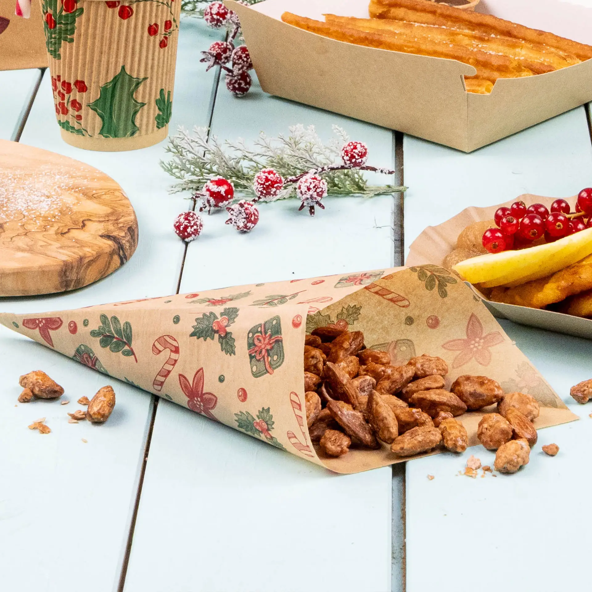 Sac en papier brun résistant à la graisse avec un design d'hiver, contenant des noix, posé sur une surface bleu clair avec des aliments et des décorations.