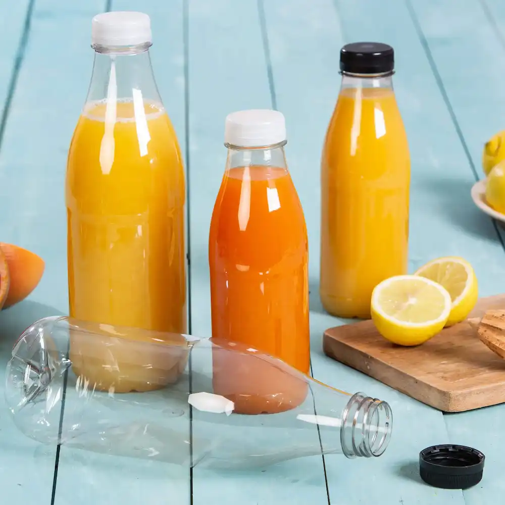Trois bouteilles en plastique remplies de jus jaunes et oranges, une bouteille est couchée, et un citron et des biscuits sont à proximité.
