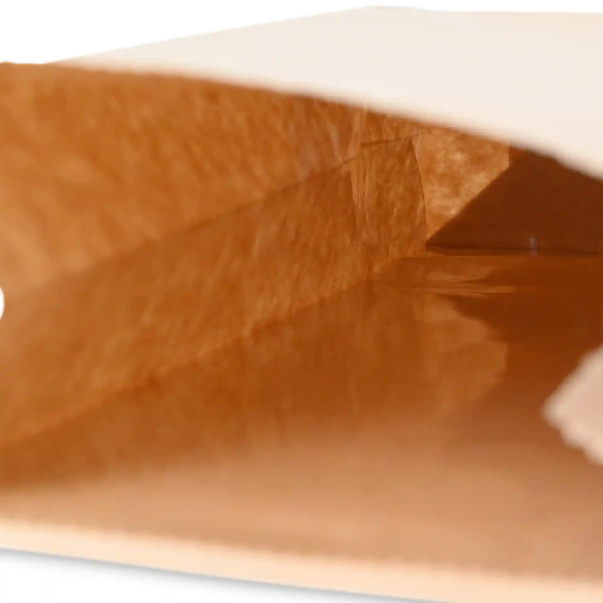 Vue intérieure d'un sac en papier kraft marron à fond plat avec un lien en métal, montrant la profondeur et la texture du sac.