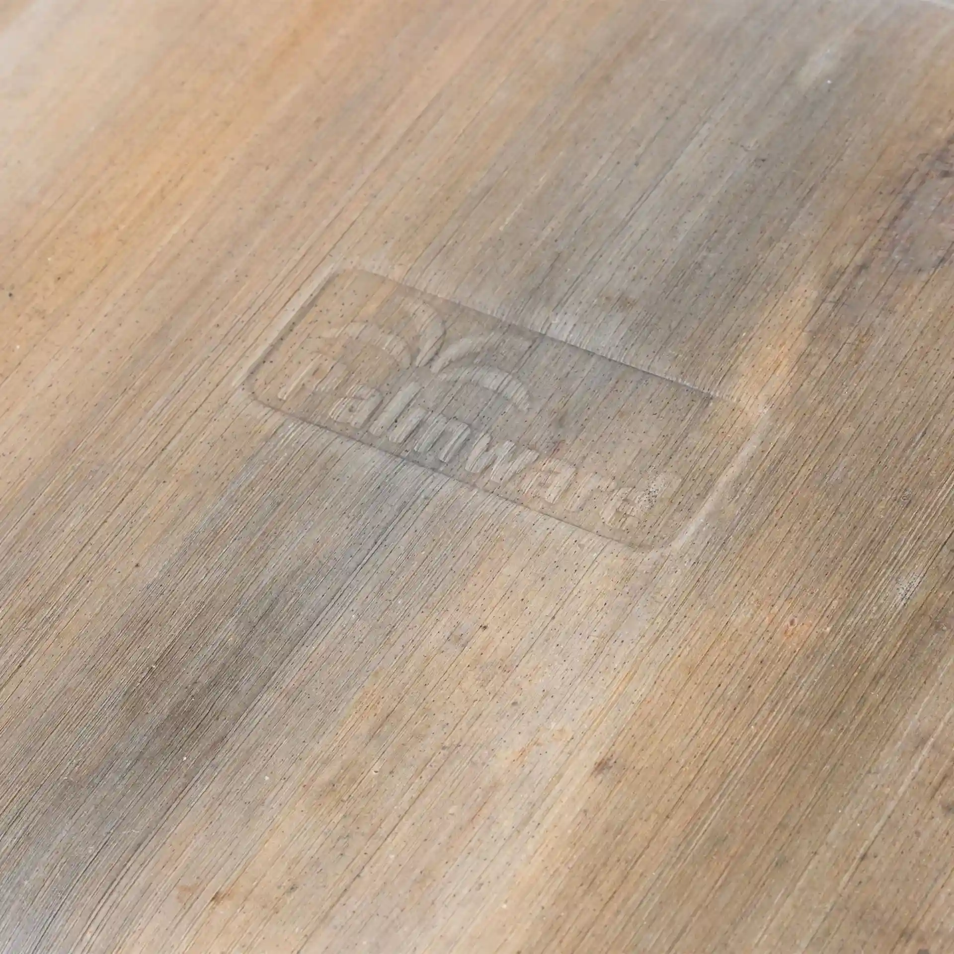 Gros plan d'une assiette en feuille de palmier montrant un logo discret sur une surface texturée.