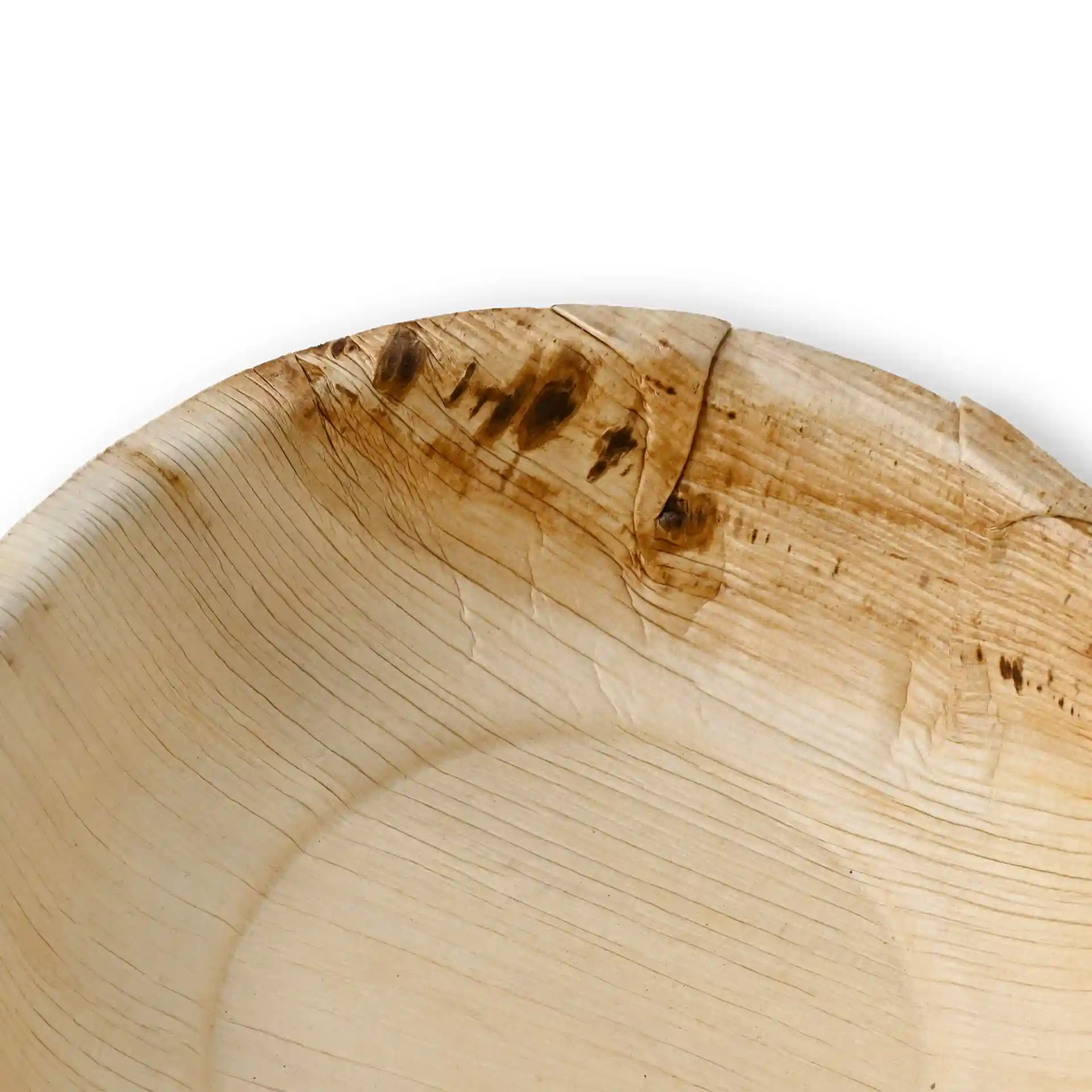Gros plan d'un bol rond en feuille de palmier avec des motifs de grain visibles et de légères imperfections sur le bord.