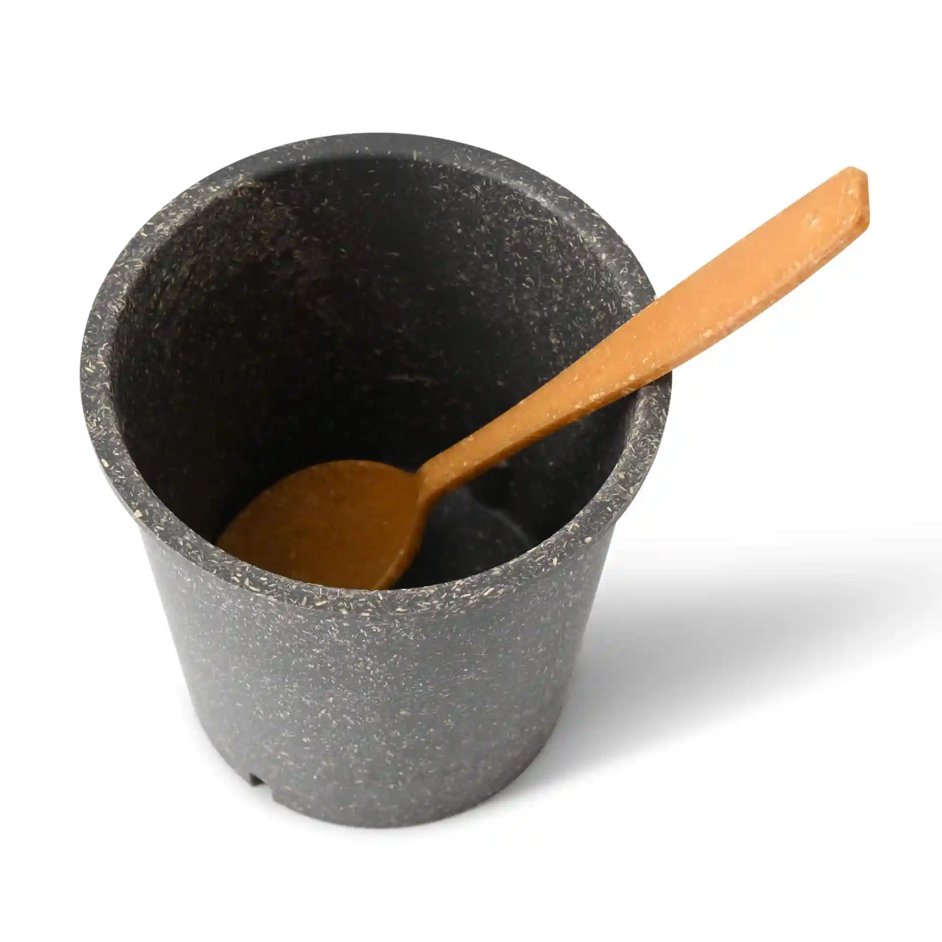 Tasse grise réutilisable ronde avec une cuillère en bois à l'intérieur, vue de dessus.