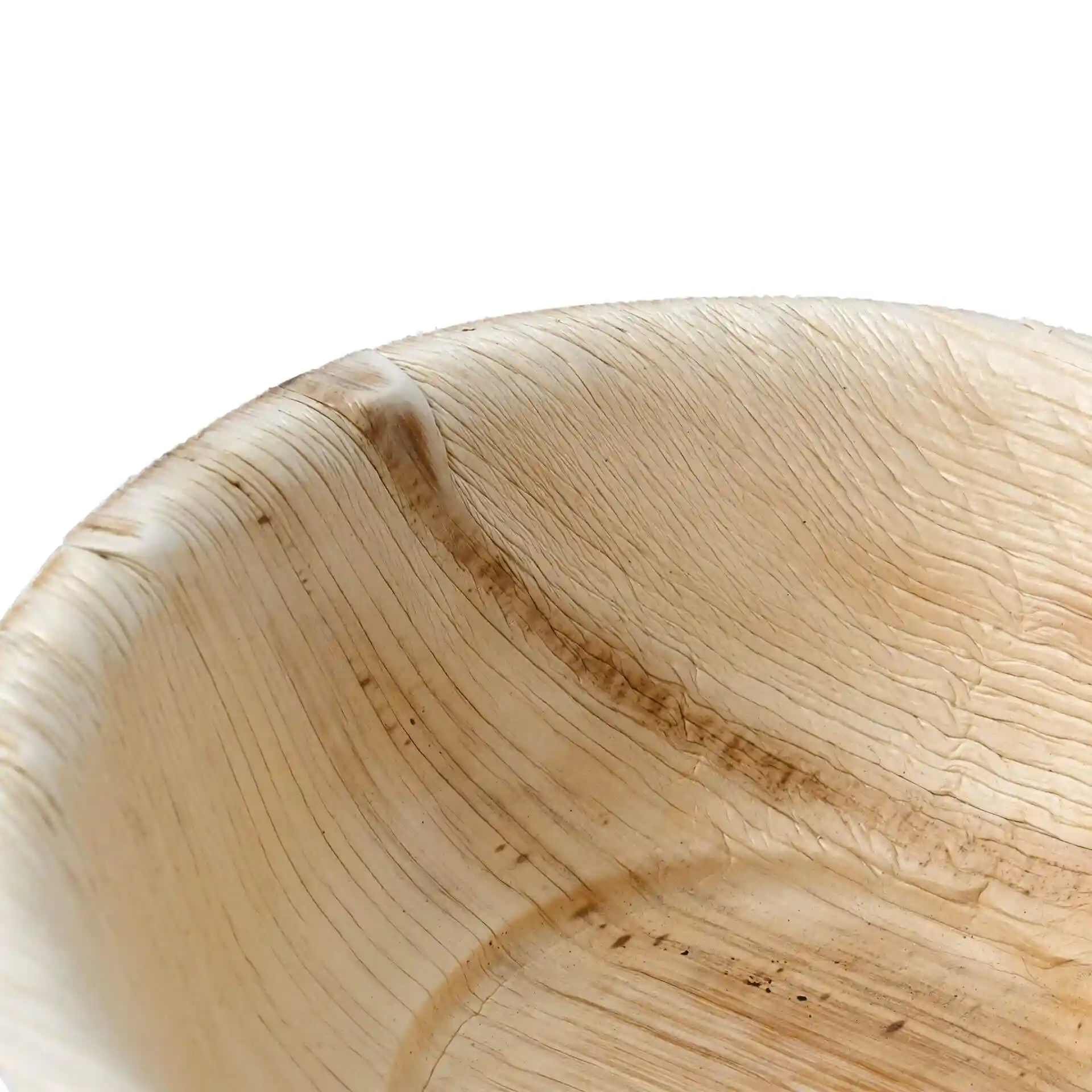 Gros plan d'un bol rond en feuille de palmier avec une texture de grain naturel, montrant les détails de la surface intérieure.