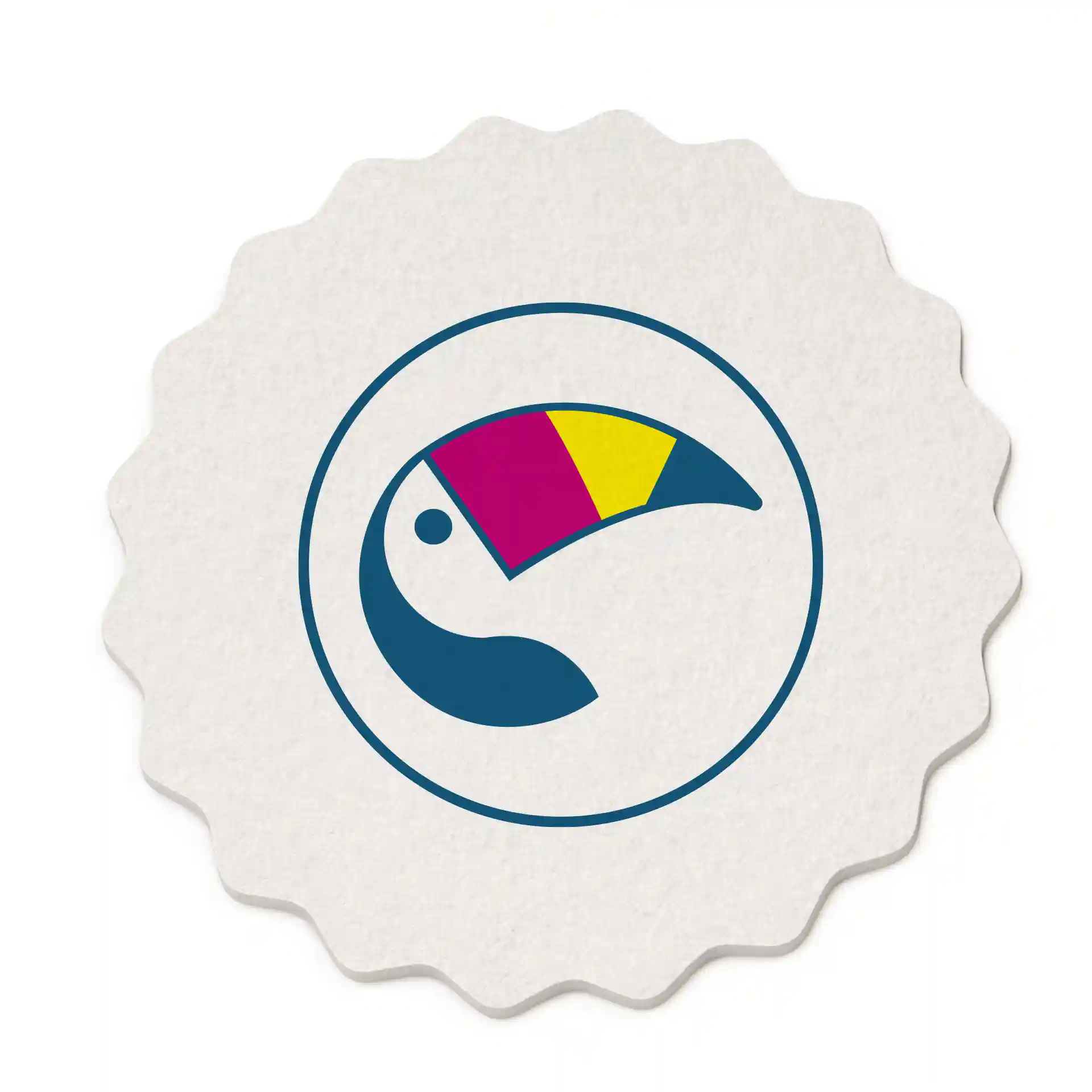 Sous-verre rond à bords festonnés avec un design coloré de toucan sur fond blanc, mesurant 10 cm de diamètre.