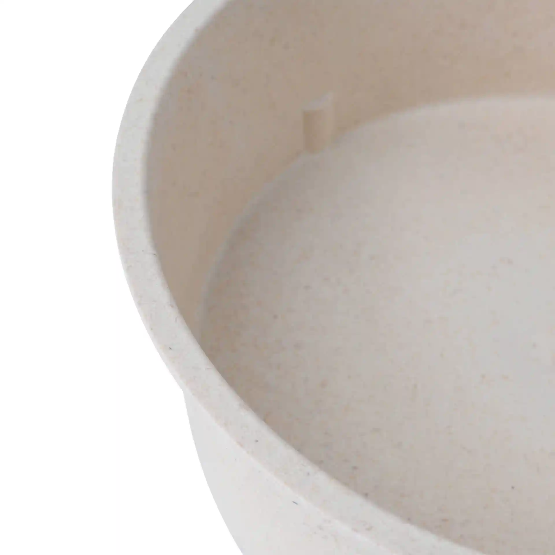 Gros plan d'un bol rond réutilisable blanc crème avec un intérieur lisse et une petite saillie à l'intérieur.