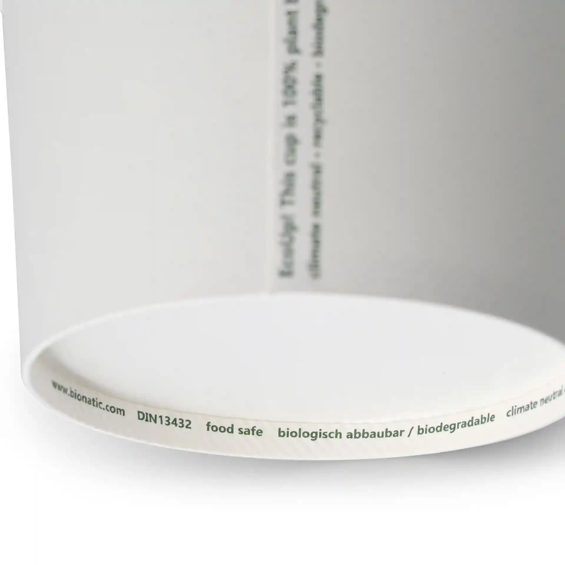 Conteneur à soupe en papier blanc de forme ronde, montrant une étiquette avec des marquages sur le bord inférieur.