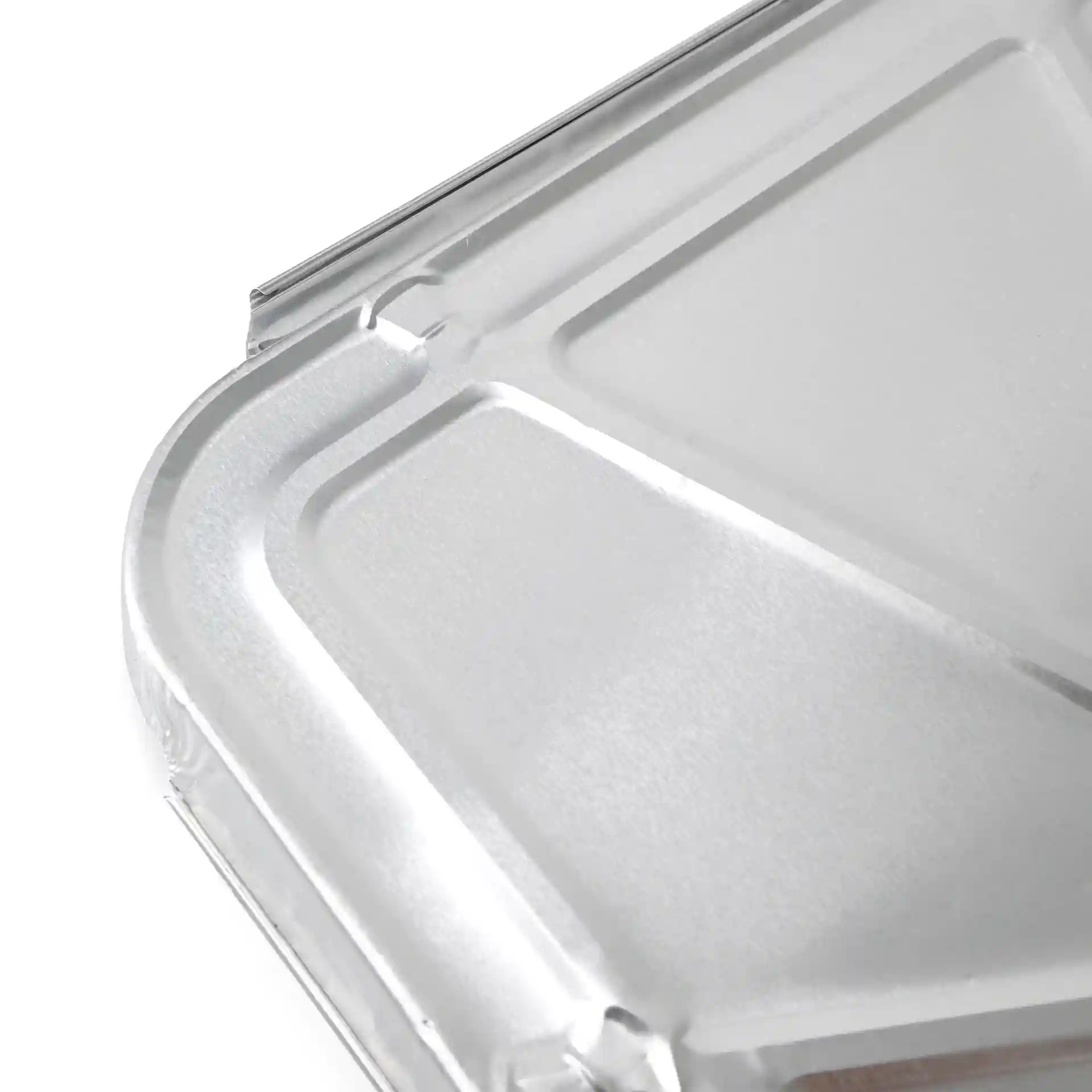 Couvercle en aluminium pour un plateau repas rectangulaire à deux compartiments, vue rapprochée de la surface et des bords.