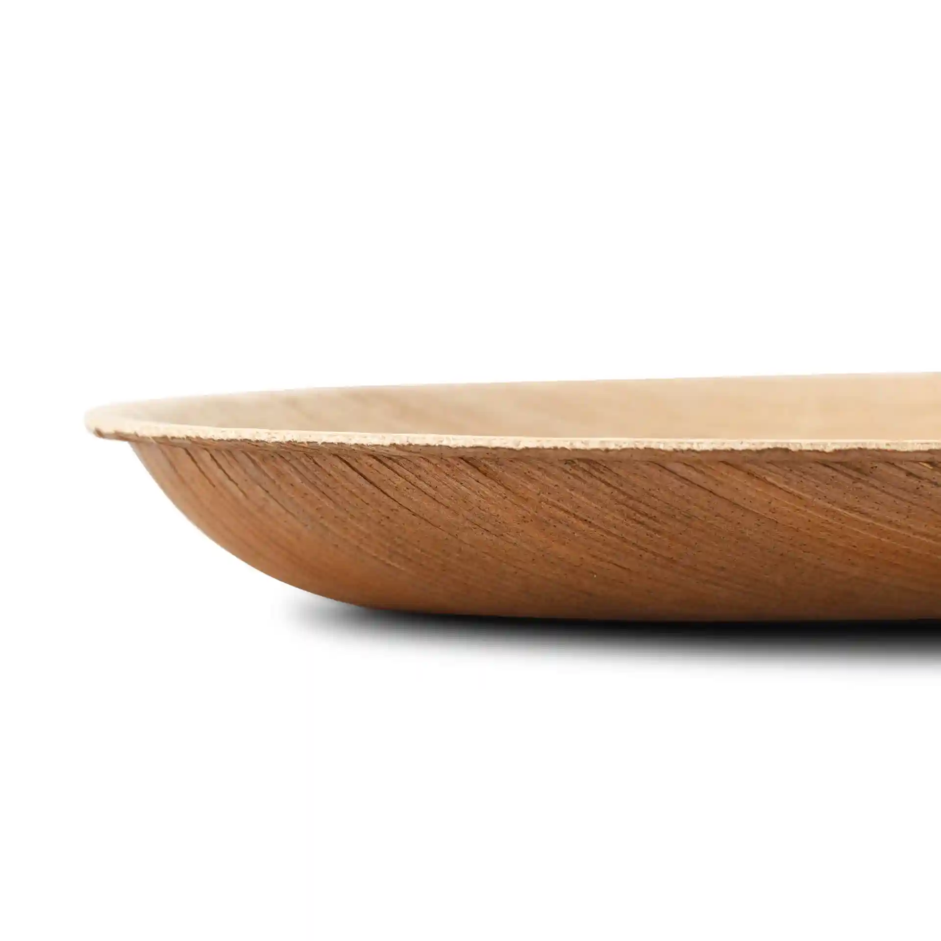 Vue latérale d'une assiette ovale en feuille de palmier avec une texture en grain, montrant un design peu profond et sans revêtement.