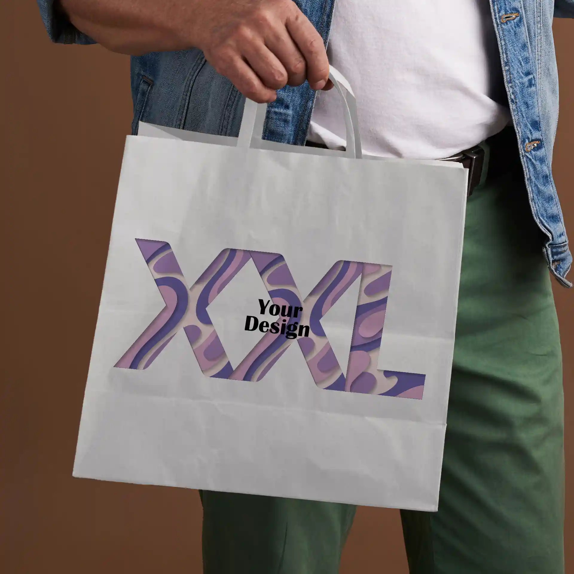 Sac en papier blanc tenu par une personne, avec un design découpé et le texte "XXL" et "Votre Design".