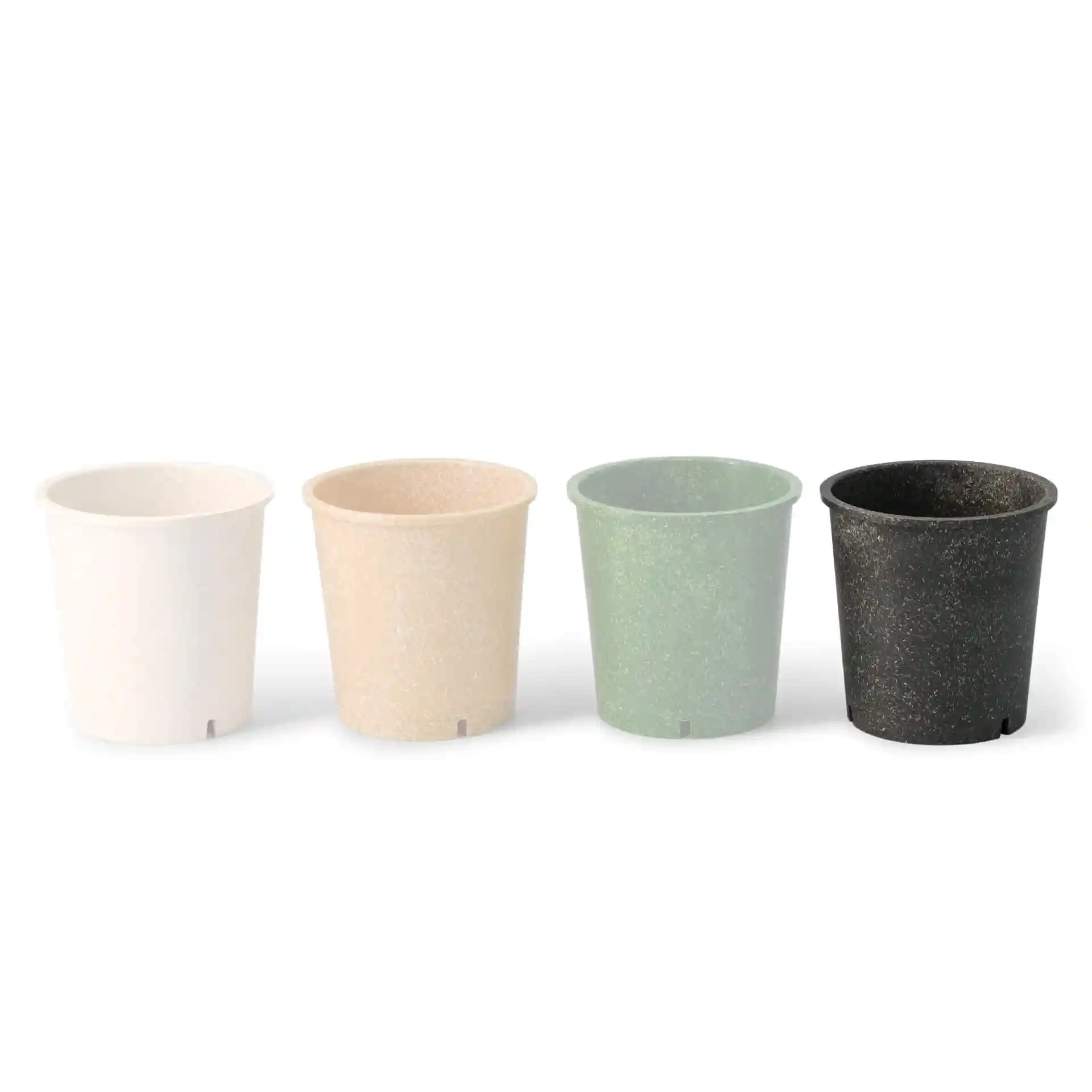 Quatre gobelets ronds réutilisables en blanc, beige, vert et noir, fabriqués à partir d'un matériau bio-composite.