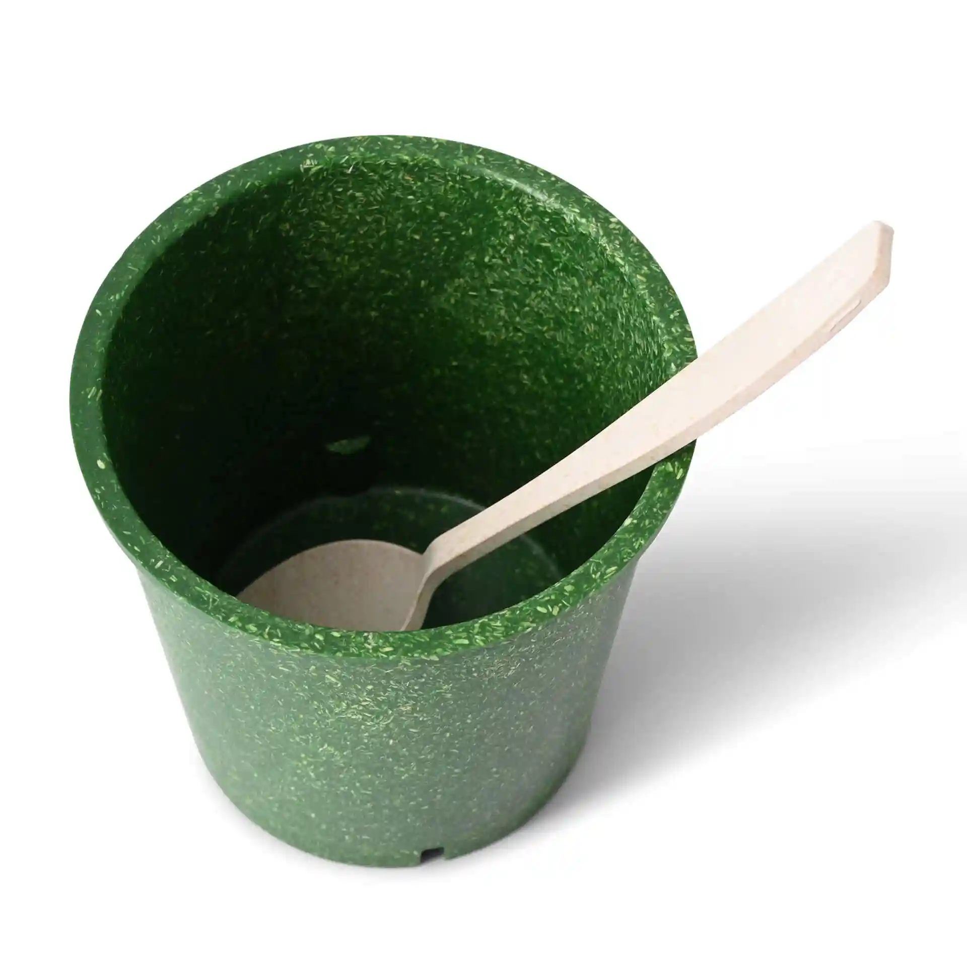 Gobelet réutilisable vert en composé bio de forme ronde avec une cuillère en bois à l'intérieur.