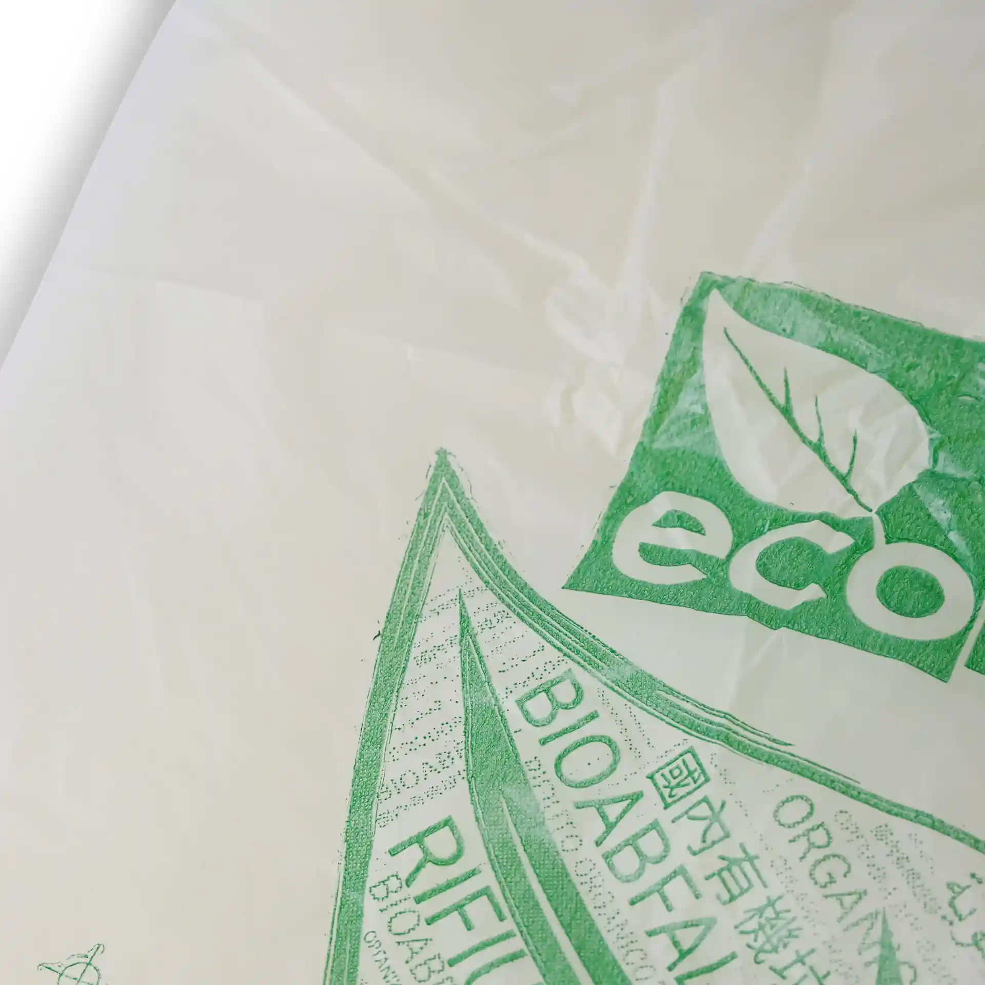 Sac poubelle bio transparent avec symboles et marquages écologiques verts, mesurant 70x70 cm.