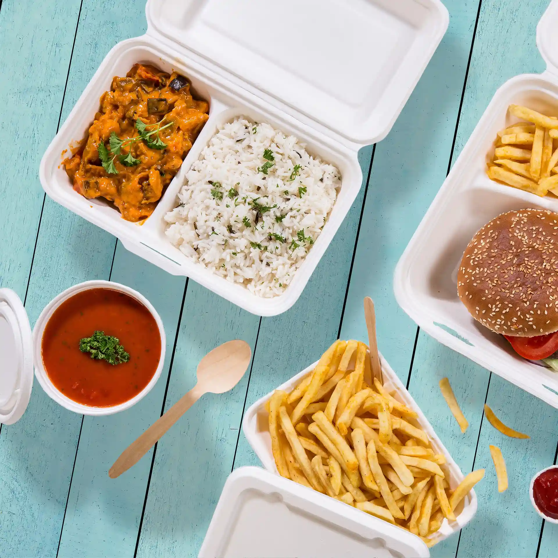 Image d'un conteneur en canne à sucre blanc crème avec deux compartiments, contenant du riz, du curry, des frites et un hamburger.