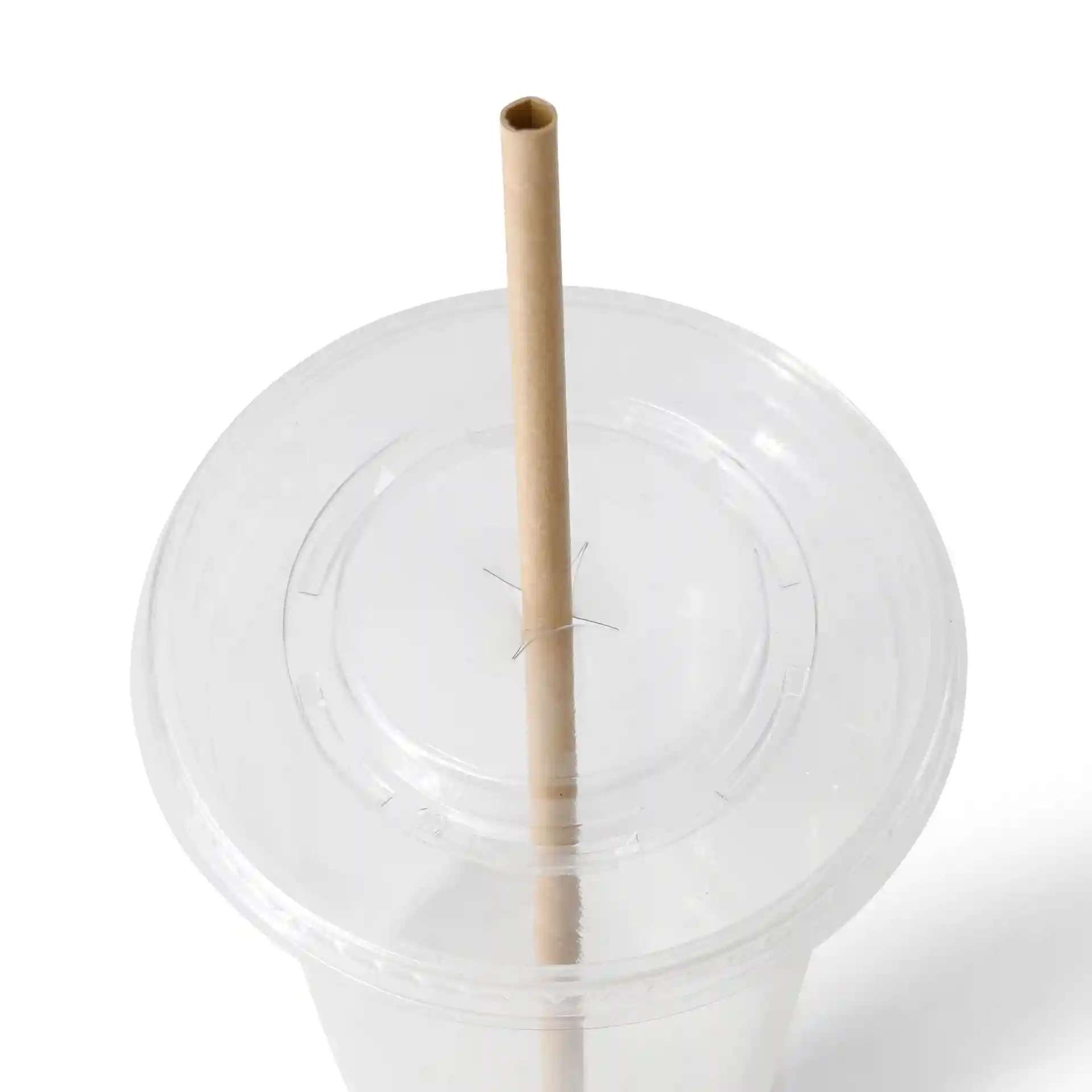 Image d'un couvercle transparent de gobelet avec un trou pour une paille en papier brun insérée verticalement.