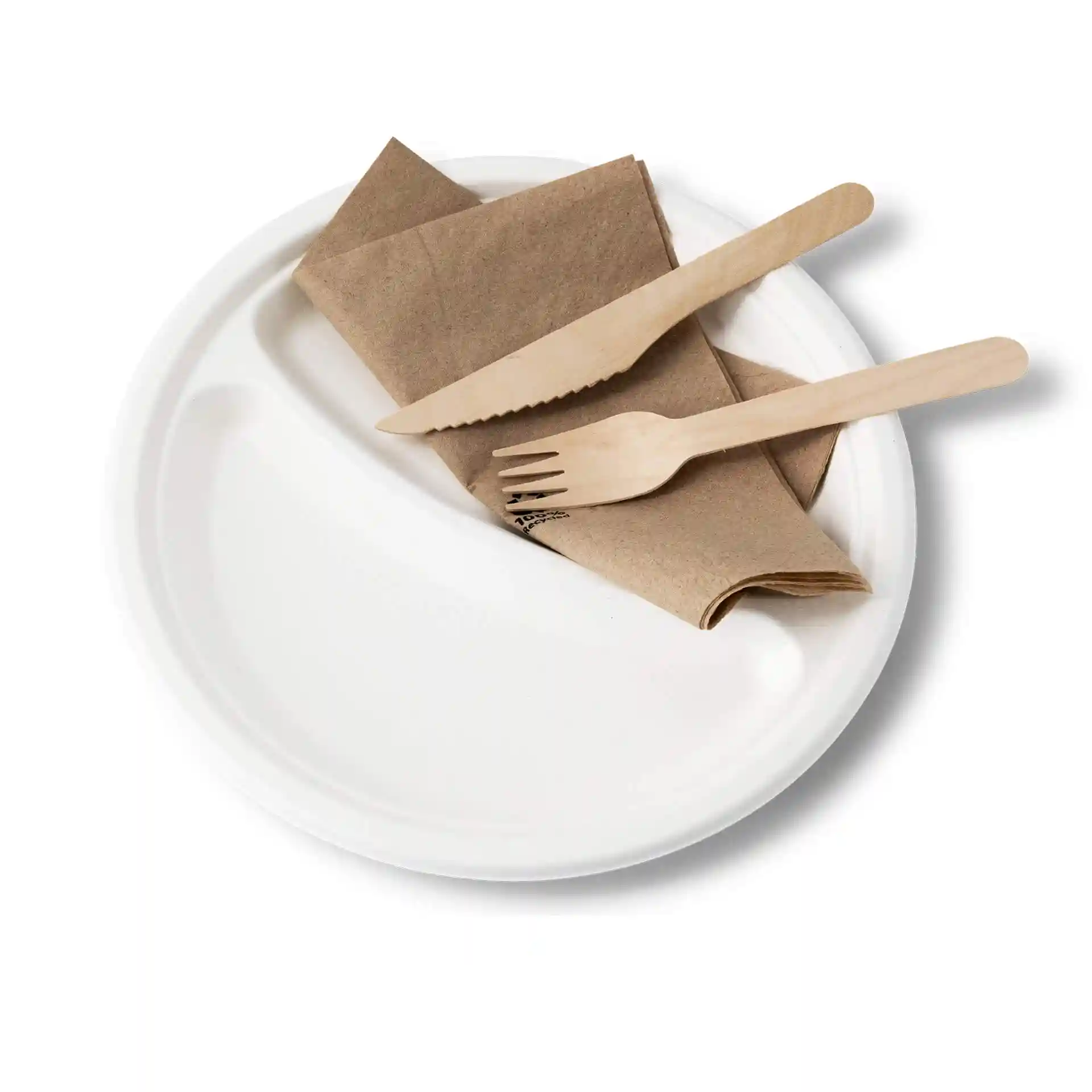 Assiette ronde en canne à sucre blanche à deux compartiments, accompagnée d'une serviette brune et d'un couteau et d'une fourchette en bois.