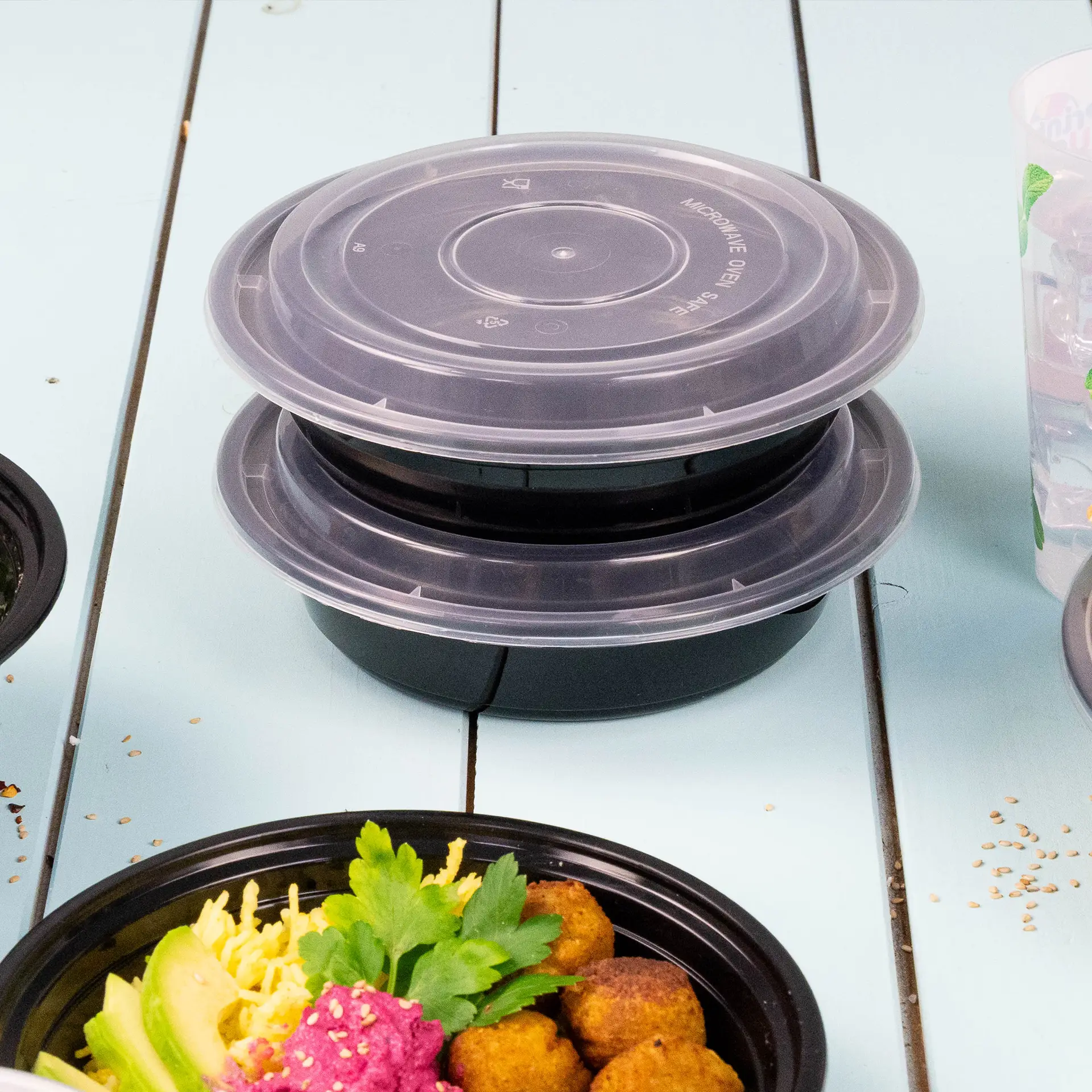 Couvercle transparent réutilisable pour contenants alimentaires, conçu pour plats chauds et froids, empilé sur des bases noires.